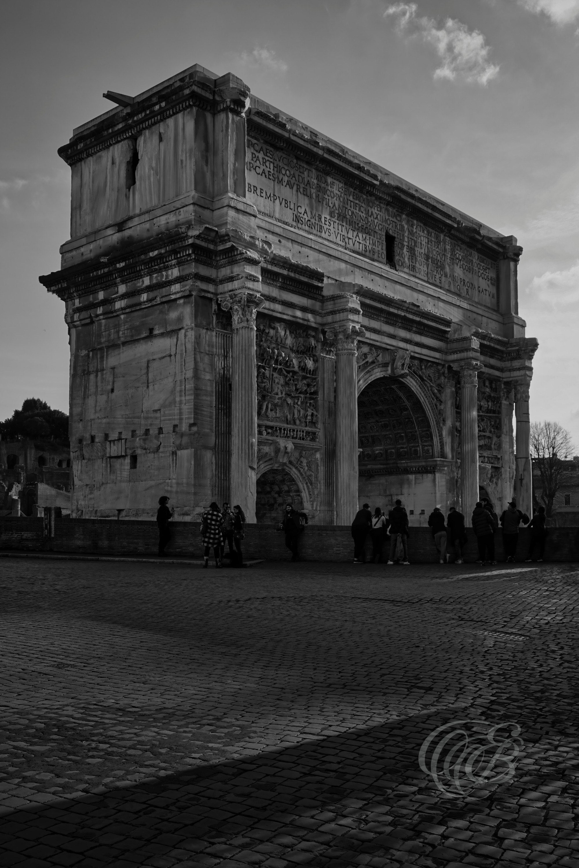 Rome, Italy — Arch of Septimius Severus at Sunset — Eduardo Bartoli Photography — Black and white photograph of the Arch of Septimius Severus in the Roman Forum, ancient Roman triumphal arch built in AD 203, illuminated by evening light in Rome, Italy — Eduardo Bartoli Photography.