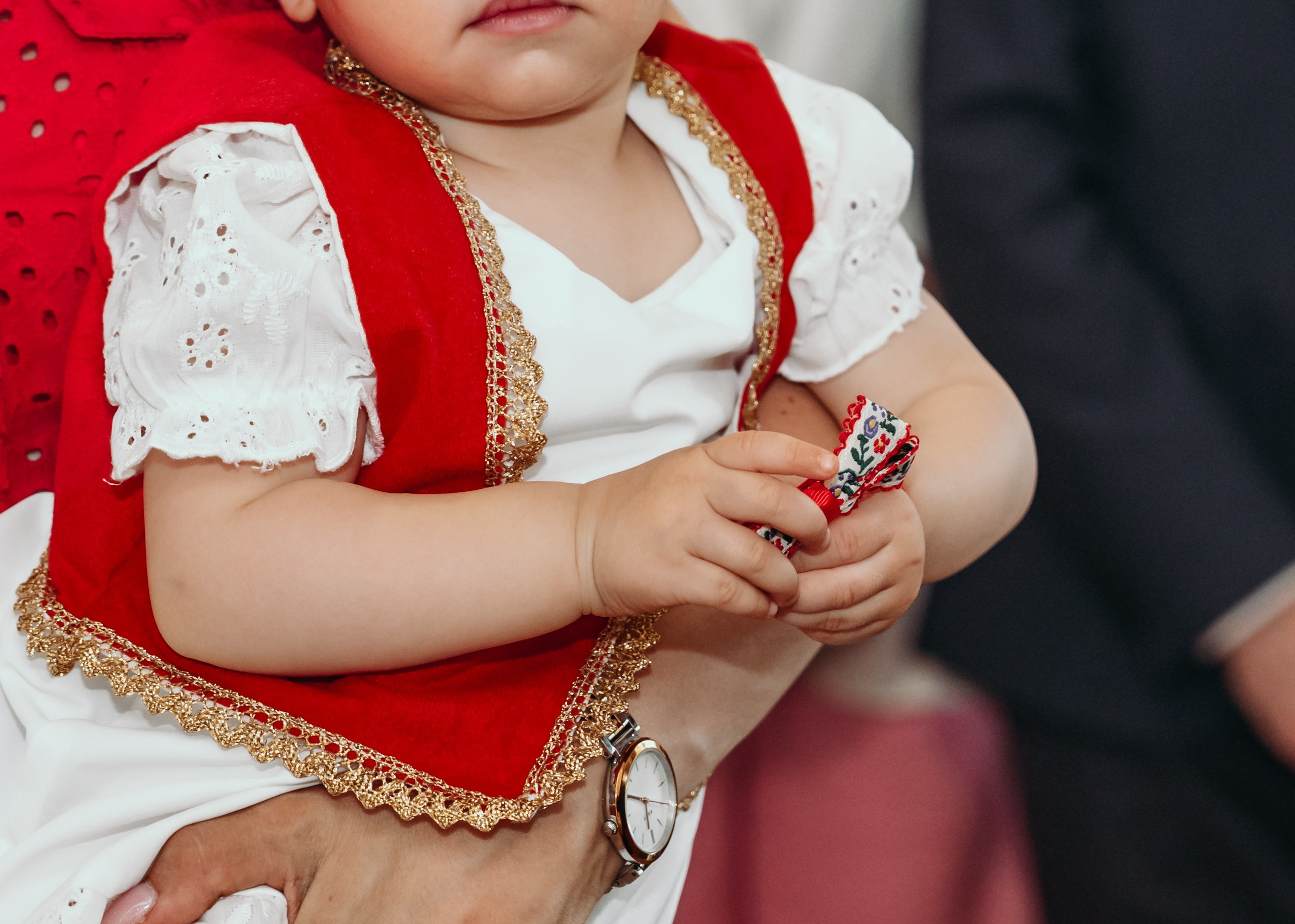 Devojcica drzi etno detalj na krstenju u manastiru Rakovica