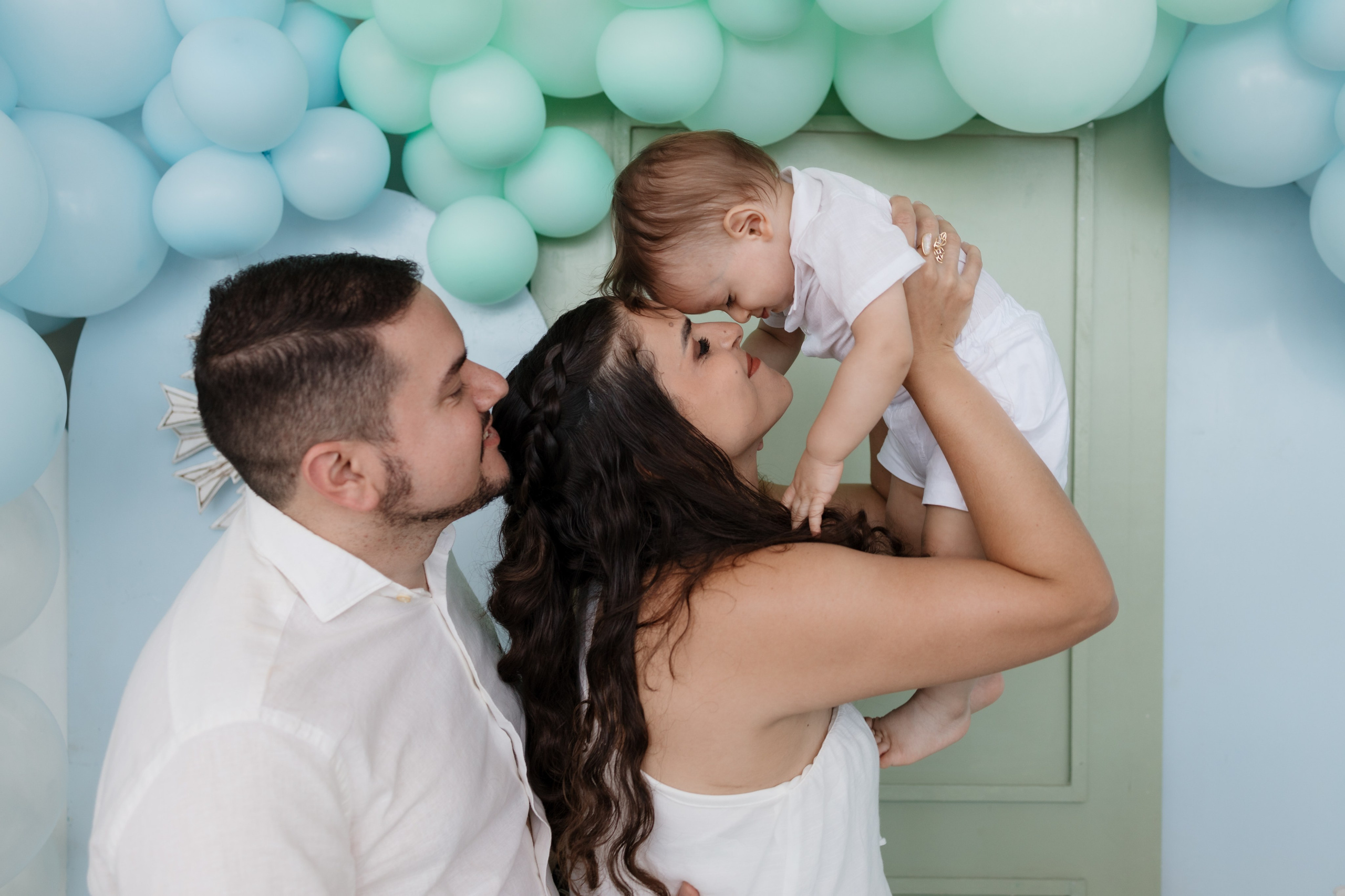 Fotografia de batizado com criança no colo dos pais