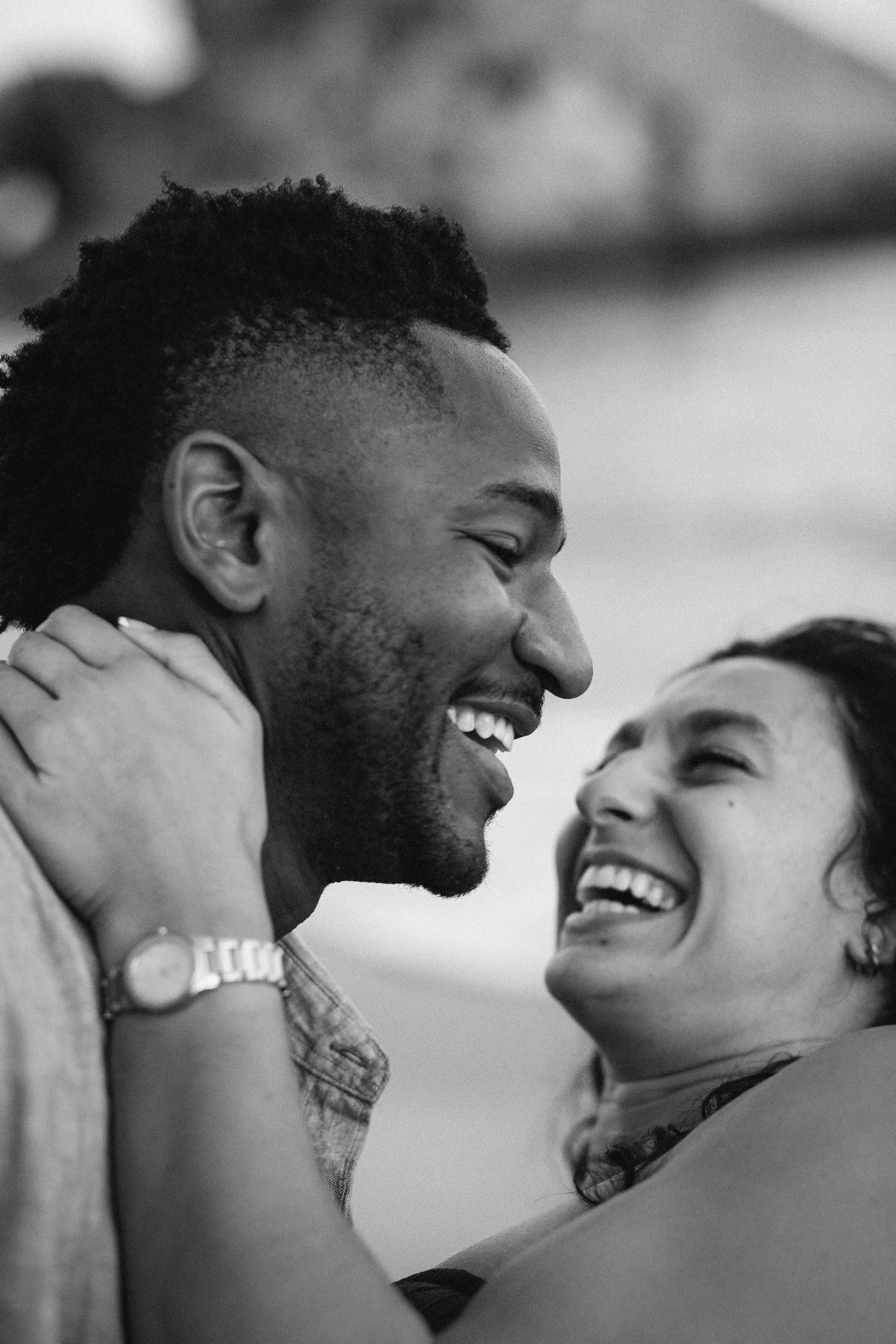 Joyful laughter shared after a surprise proposal during a destination engagement shoot in Málaga, Spain. Emotional engagement photography capturing authentic connection and romantic energy by the Mediterranean.