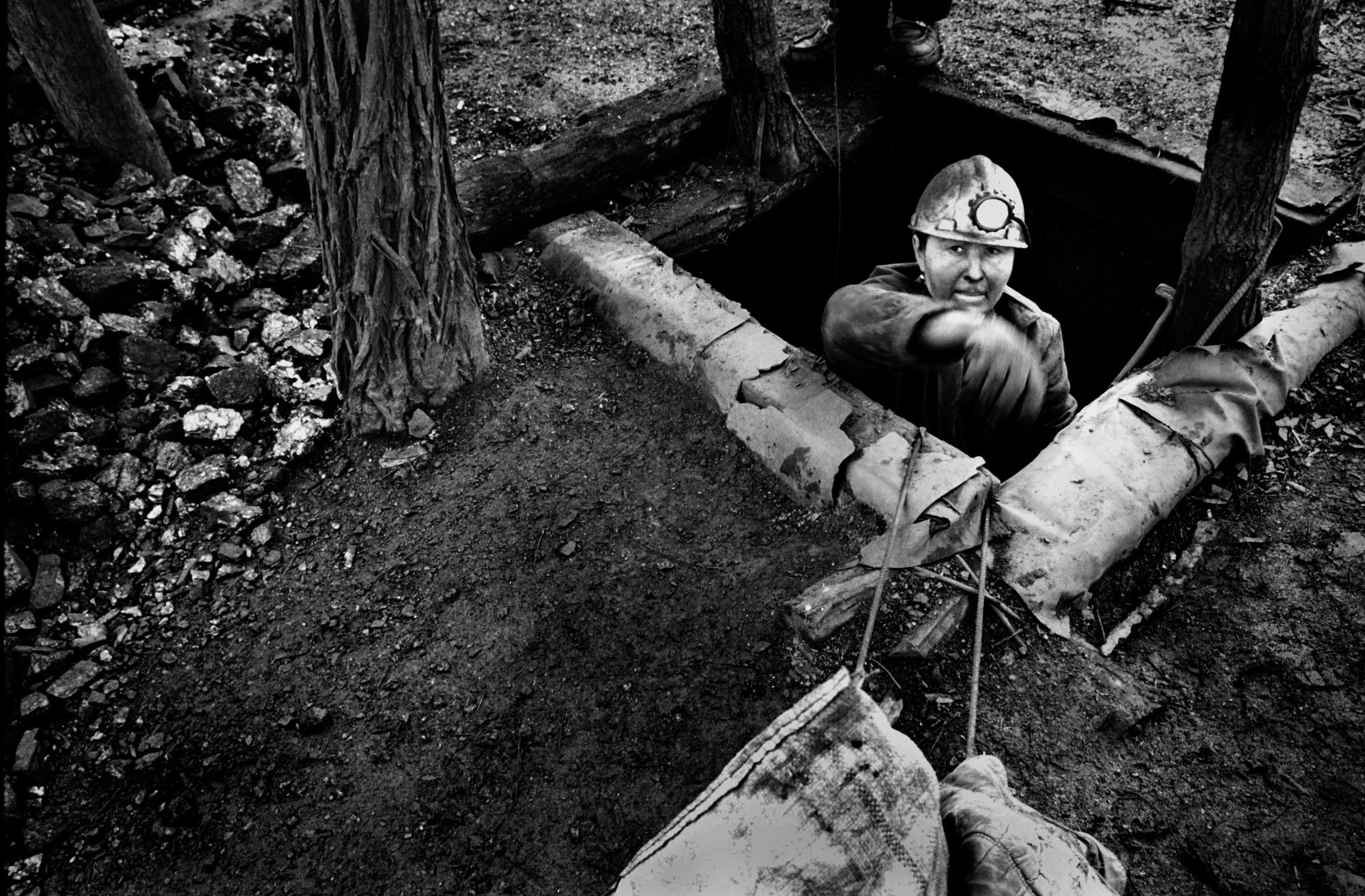 A weary Natasha, 40, climbs out of a mine shaft after several hours of work February 25, 2002 near Snezhnoye, Ukraine. Her husband left her when he couldn't take care of the family anymore and then her father died in a mining accident, forcing her to pick up where the men left off. 