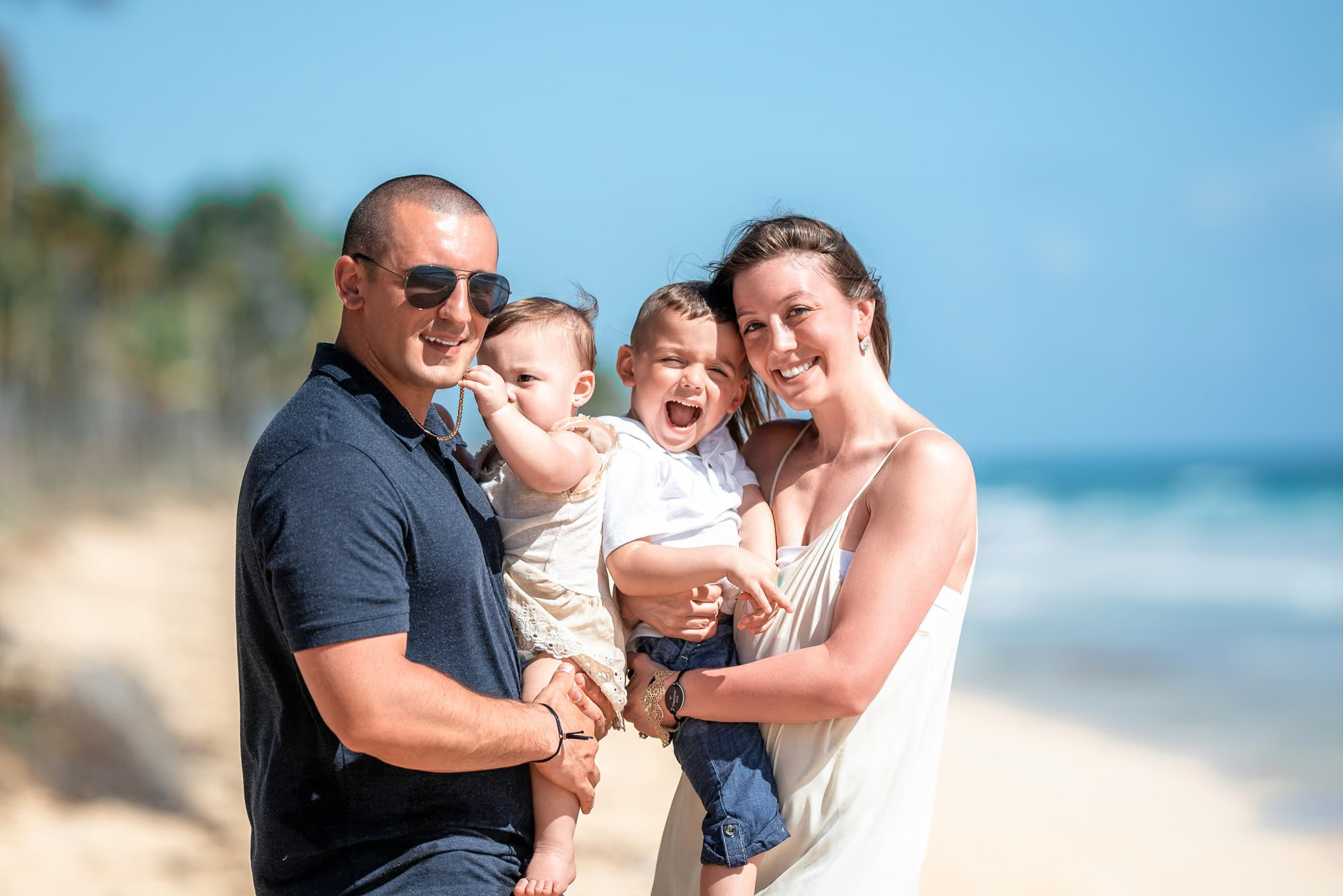 Beach photo session Punta Cana featuring a happy family walking along the shoreline.