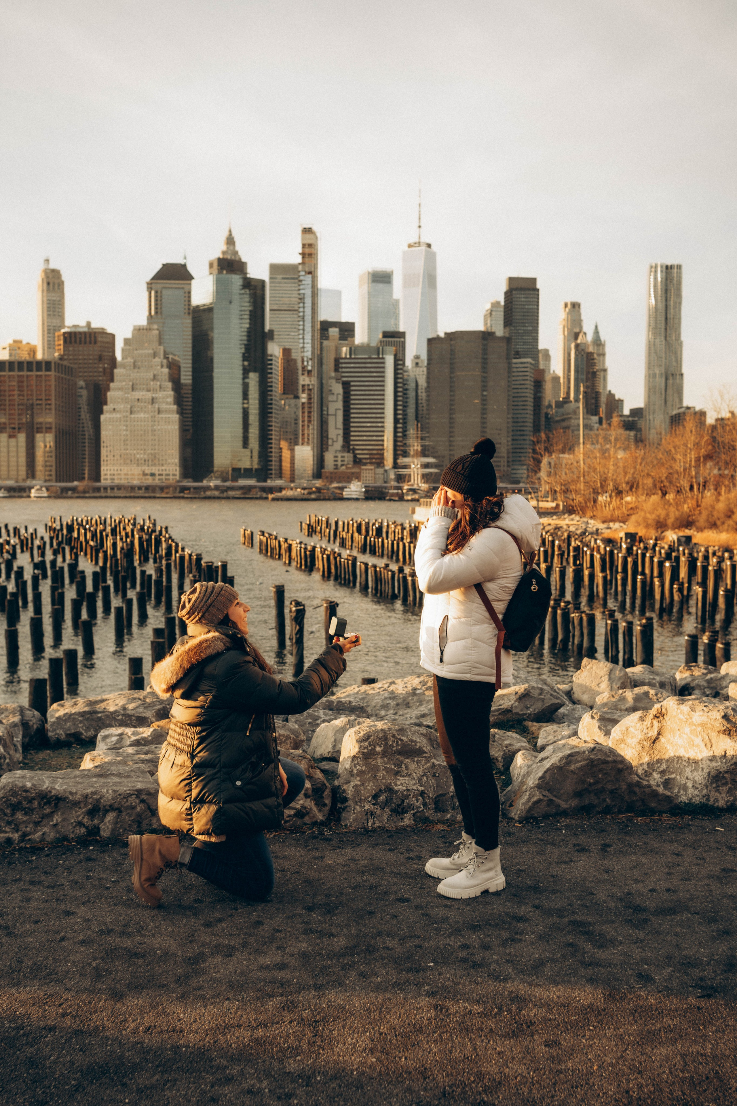 Emotional couple kissing after Empire State Building proposal.