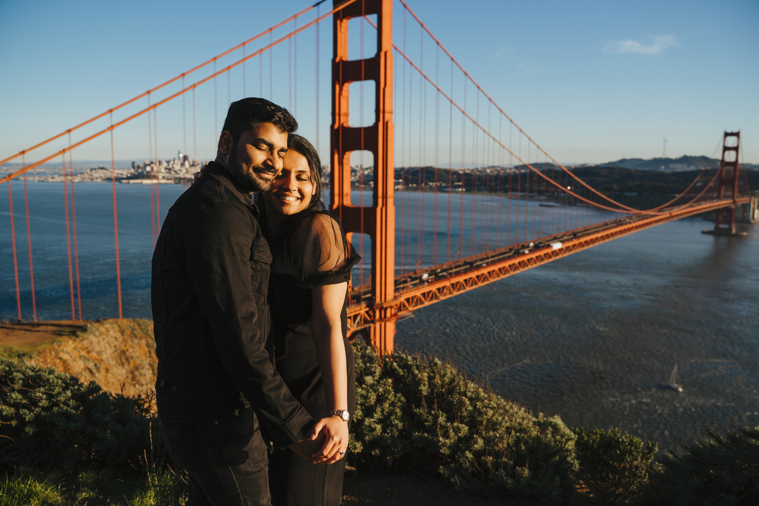Proposal.  Overlooking the golden San Franisco Bridge sunset with a couple. Photographer Video. 