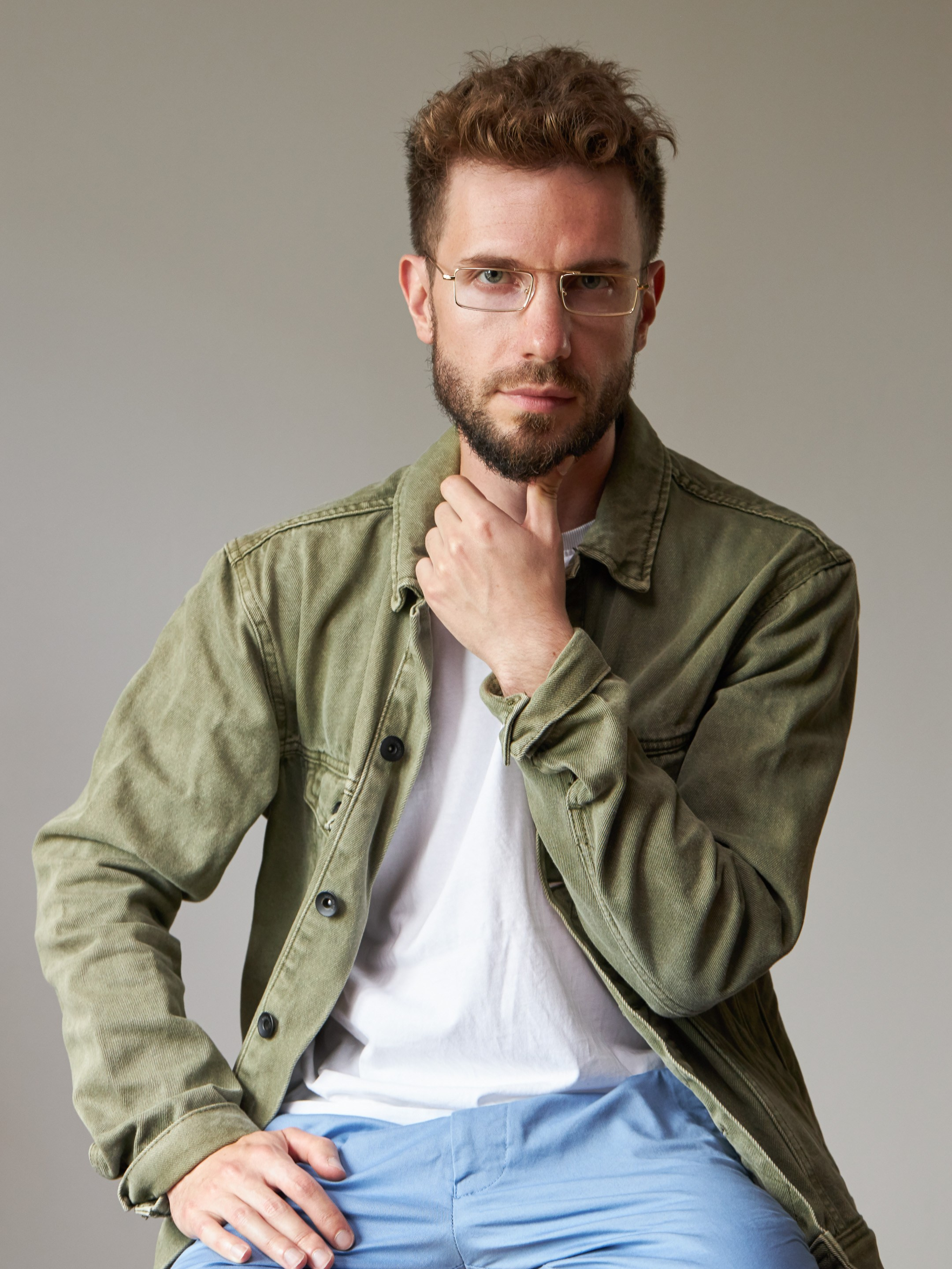 Eyewear model photoshoot - studio portrait of a young man on warm grey background - photographer Andrey Dunin