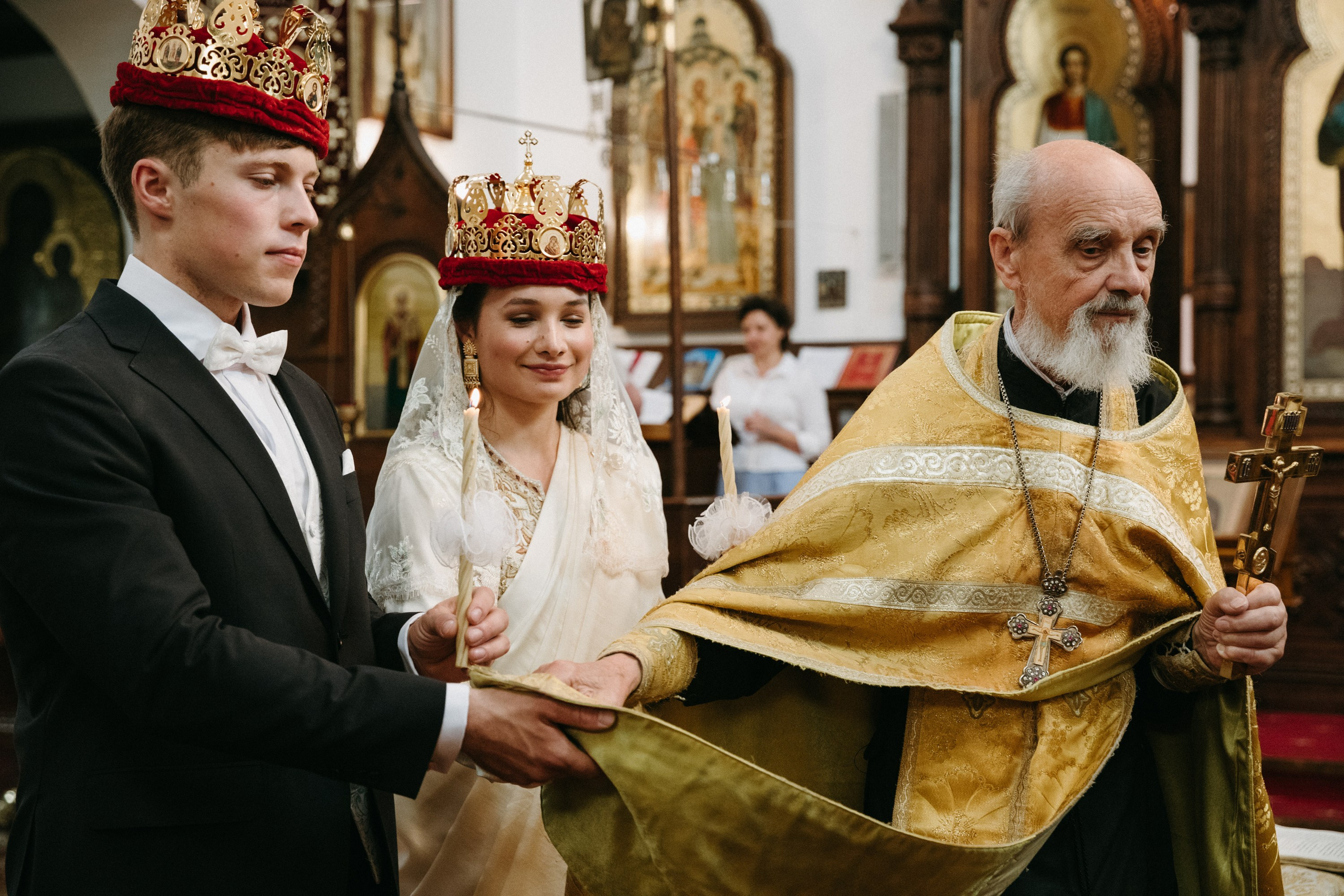 Braut und Bräutigam folgen dem Priester in der traditionellen orthodoxen Hochzeitsprozession