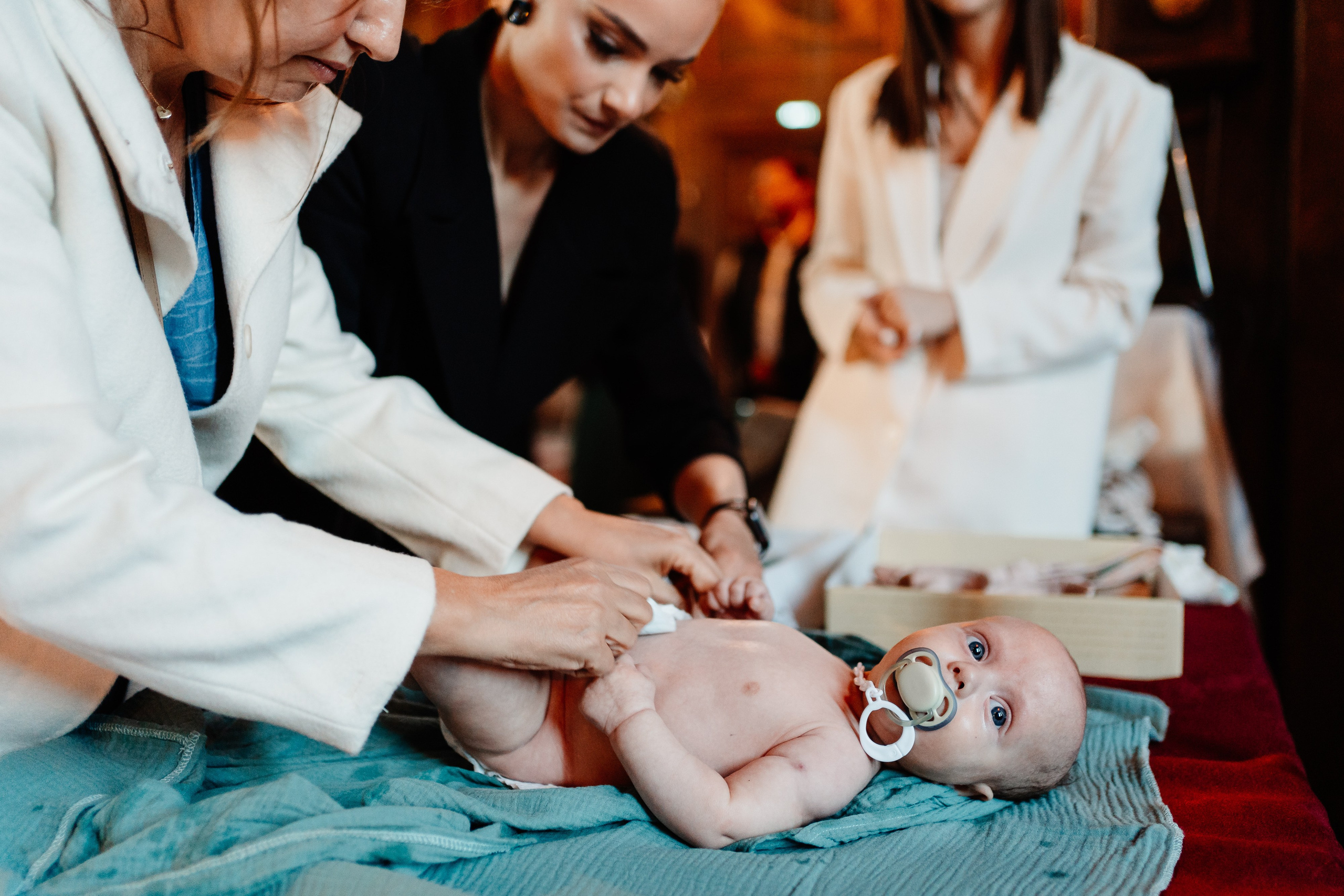 Instantaneu plin de tandrețe dintre părinți și bebeluș în ziua botezului, realizat în Craiova. Fotografie profesională de botez, capturând emoțiile autentice ale familiei într-un decor luminos și cald