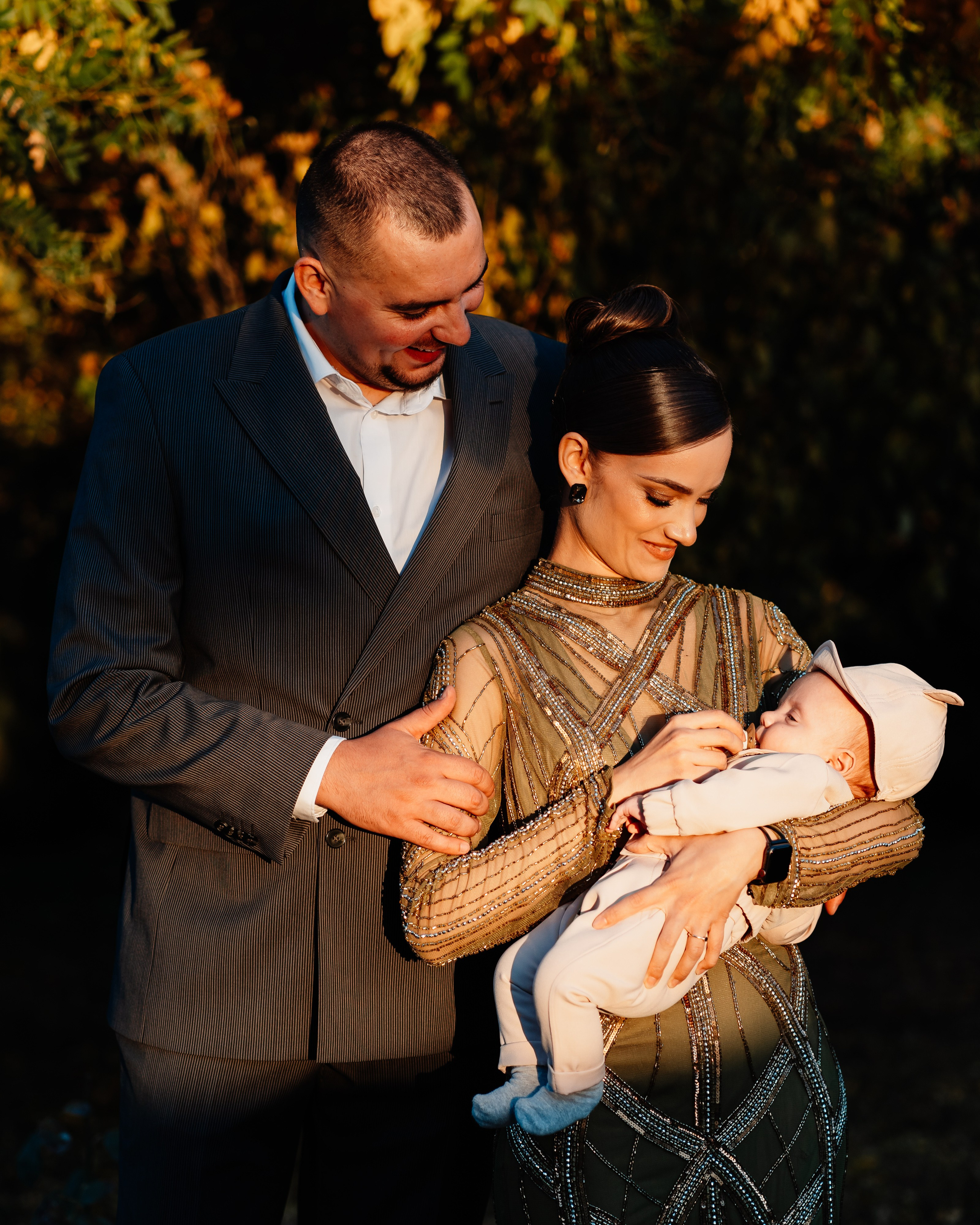 Instantaneu plin de tandrețe dintre părinți și bebeluș în ziua botezului, realizat în Craiova. Fotografie profesională de botez, capturând emoțiile autentice ale familiei într-un decor luminos și cald