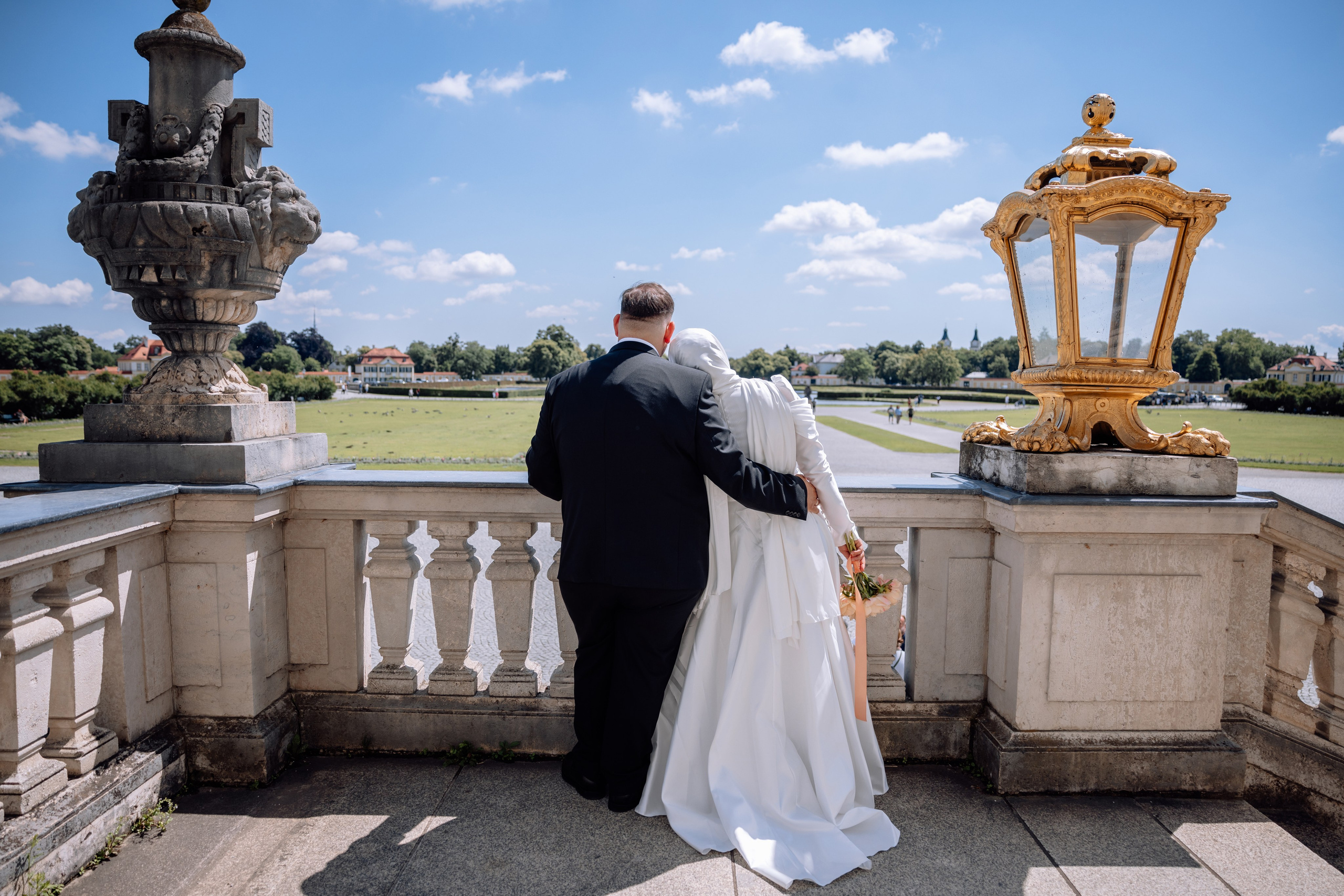 Paar schaut verliebt in die Ferne vor dem Schloss Nymphenburg