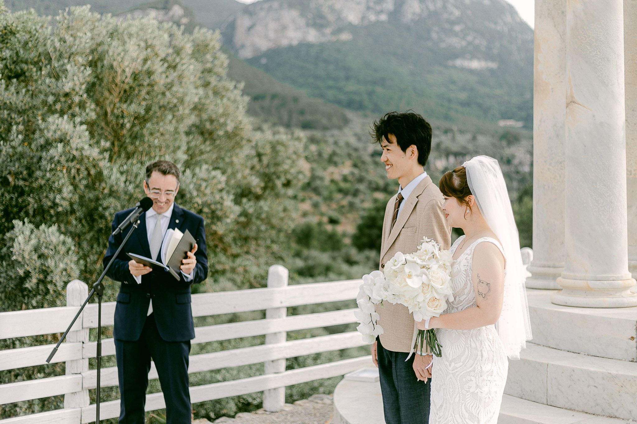 Wedding officiant reading the ceremony at the Son Marroig temple overlooking the Mallorca coastline