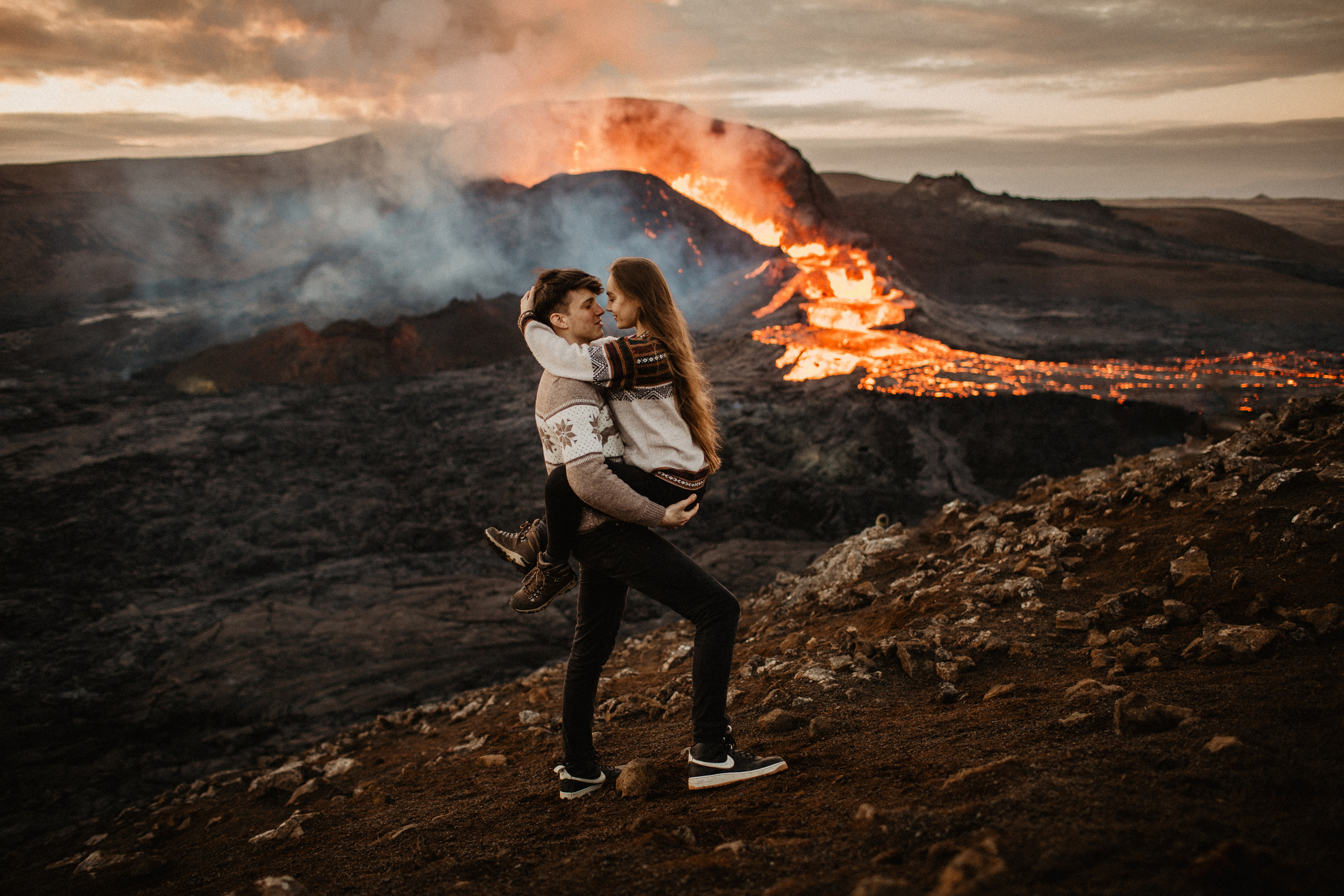 Couple photoshoot in front of volcano eruption in Iceland. Iceland elopement photographer & videographer
