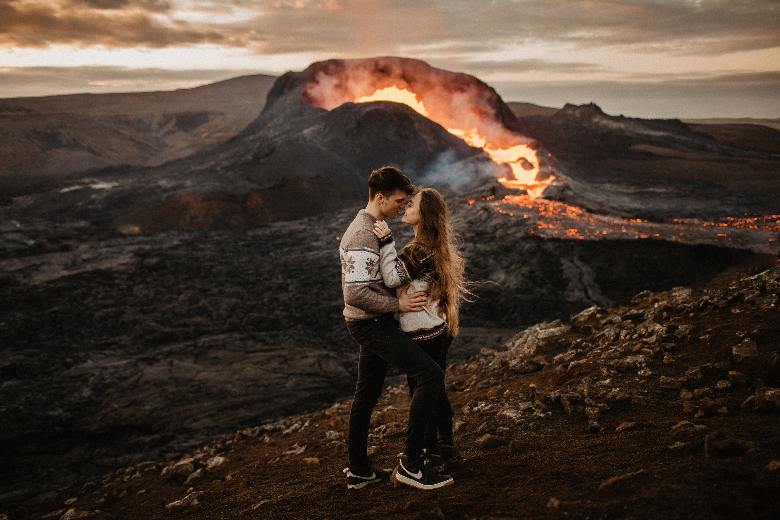Couple photoshoot in front of volcano eruption in Iceland. Iceland elopement photographer & videographer