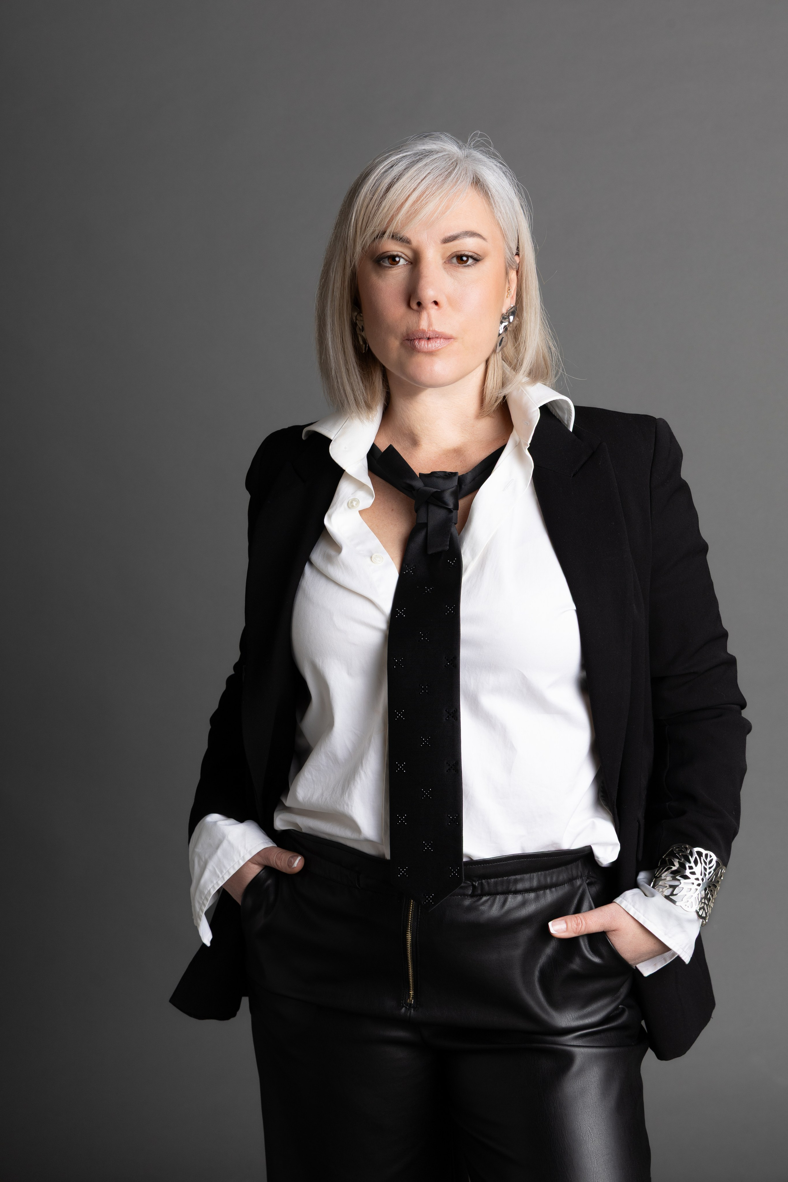 Portrait corporate d’une femme en tenue professionnelle, photographiée en studio dans une ambiance élégante et intemporelle.