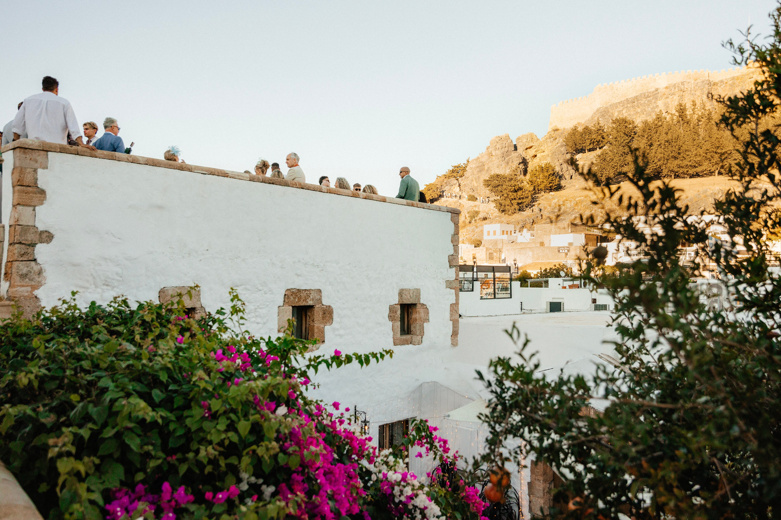 The view of Acropolis and guests in the wedding in Lindos, Rhodes, Greece