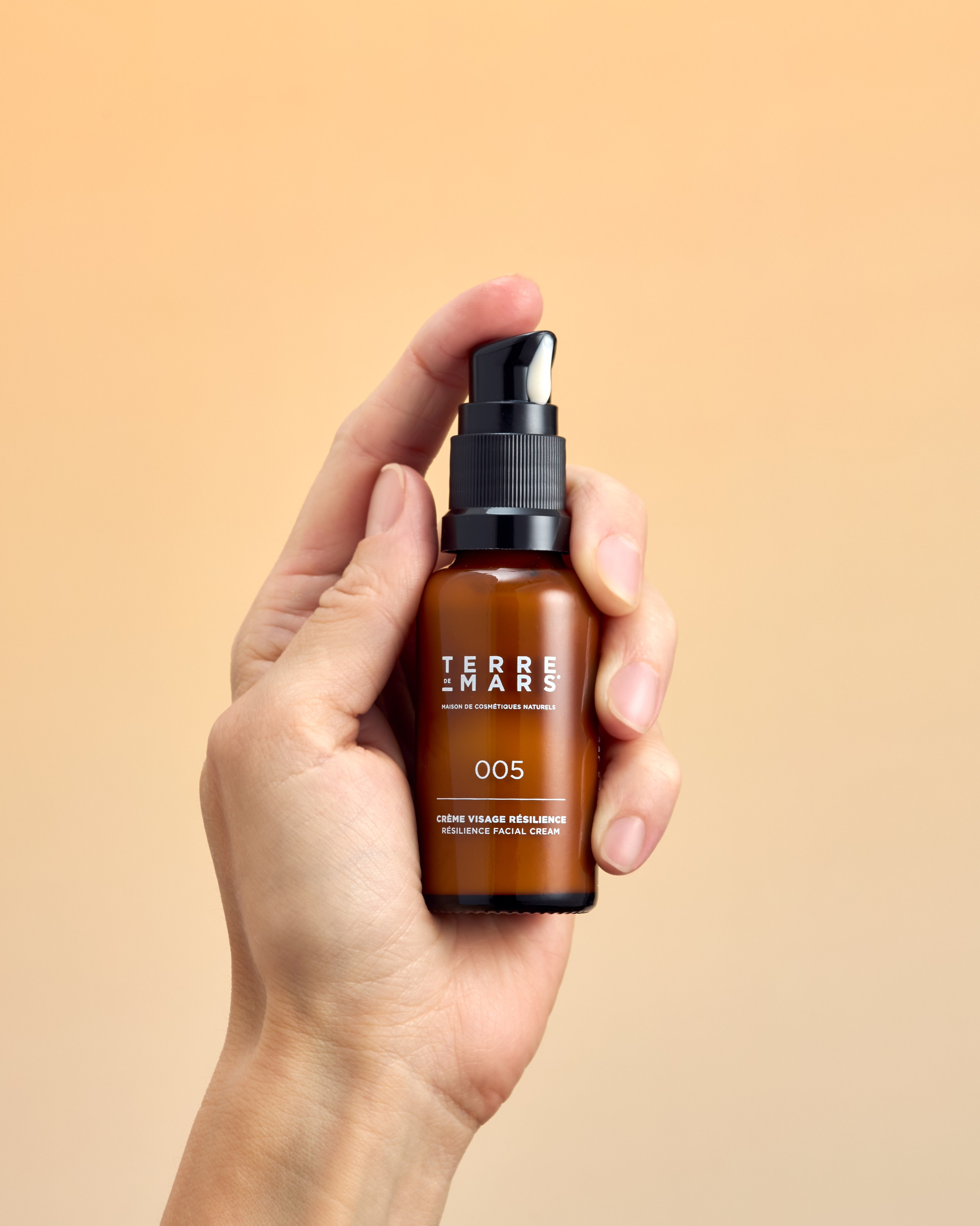 Hand hält Gesichtscreme, Textur sichtbar beim Dosieren, professionelle Werbefotografie für Social Media und Marketing