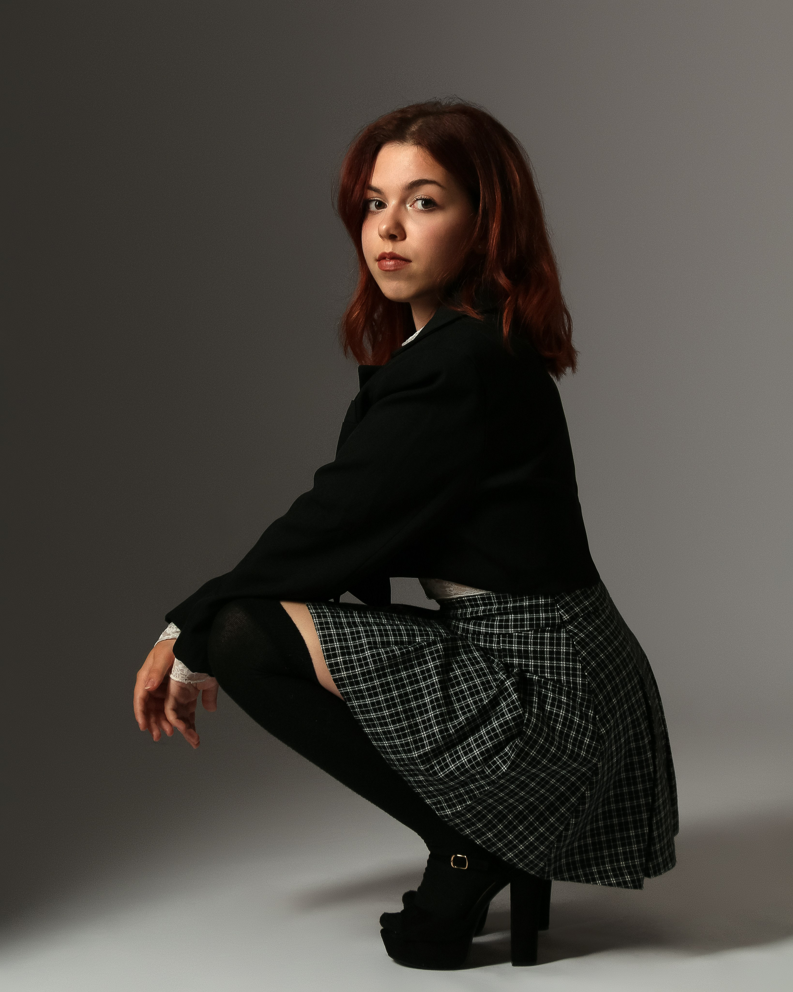 Kreatives Fashion-Foto im Studio: Frau in stylischem Kostüm mit starkem Ausdruck