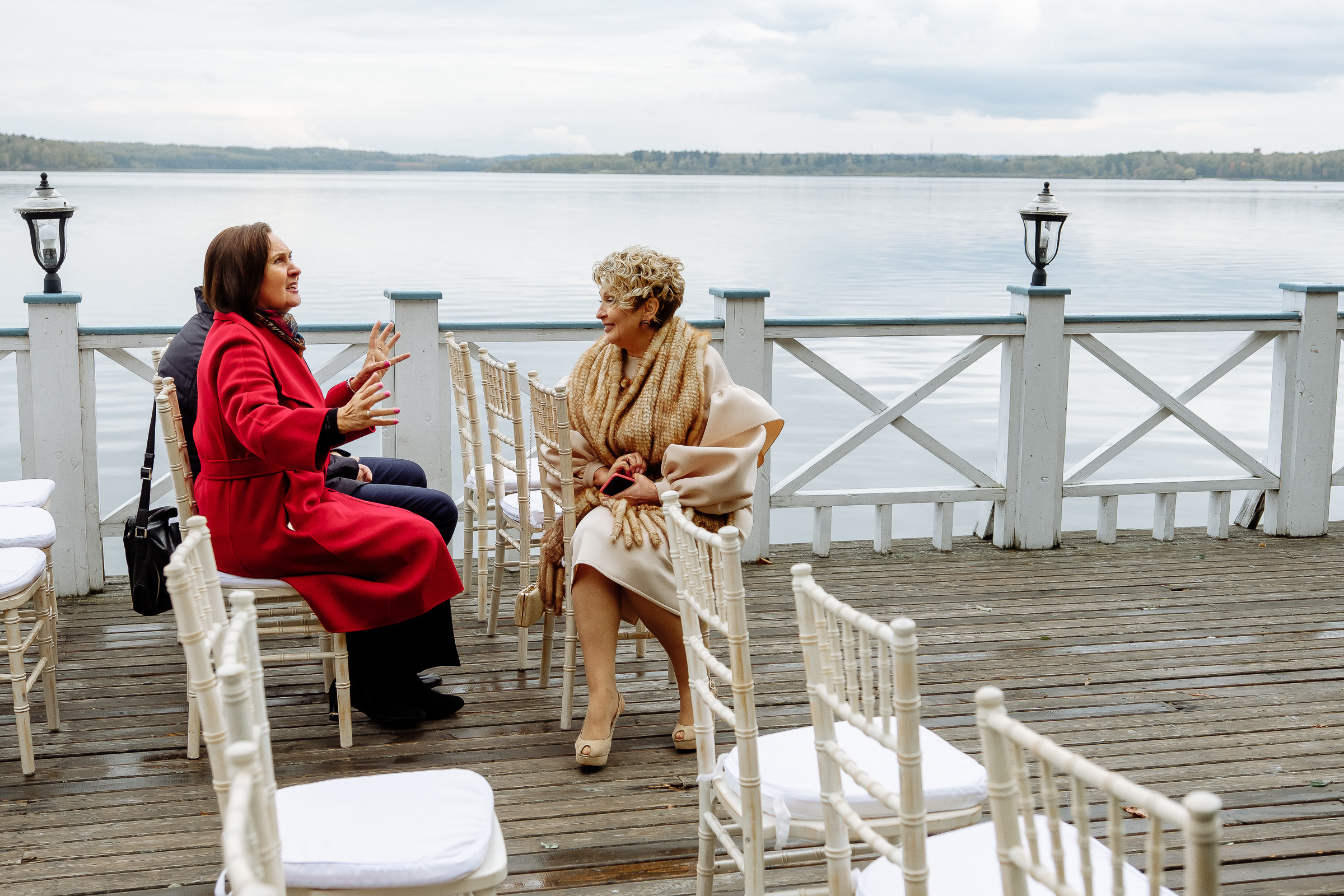 Guests talking on riverboat deck, by Tanya Bodgan, Bude, Cornwall wedding photographer.  