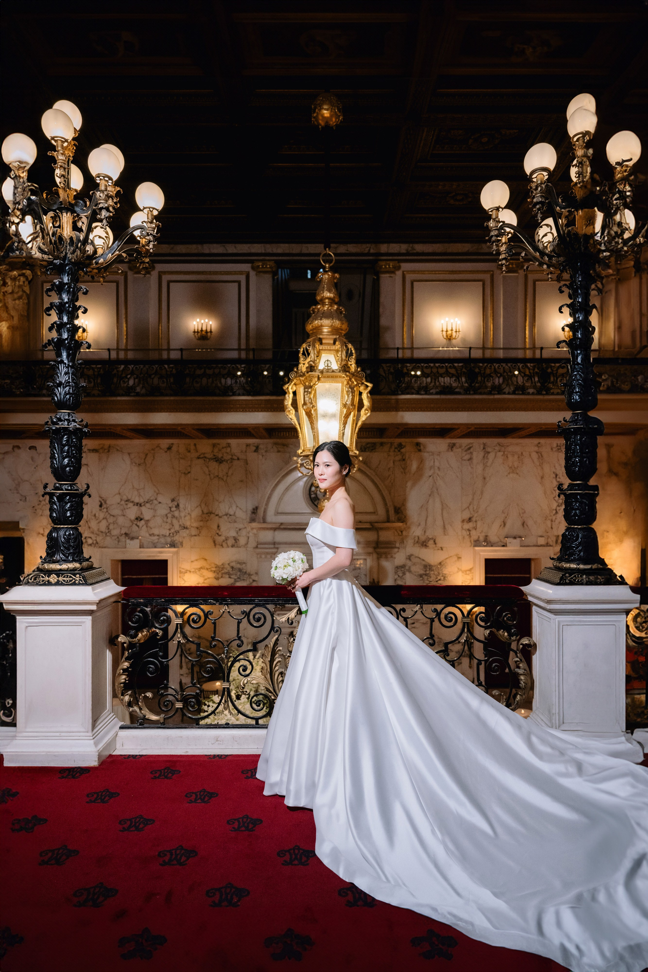 a bride in a white wedding dress standing in front of a red carpet