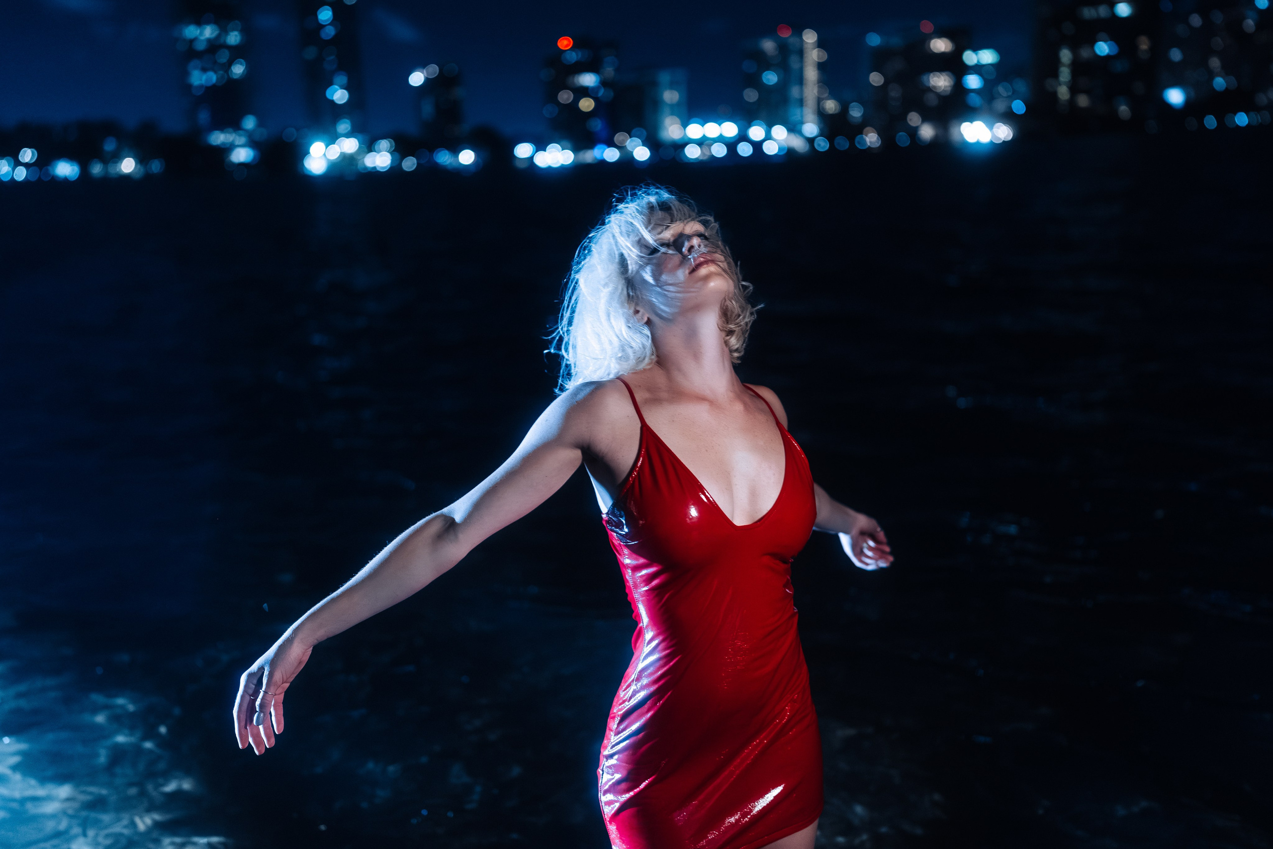 The model faces the wind, dress moving. The frame feels emotionally open.