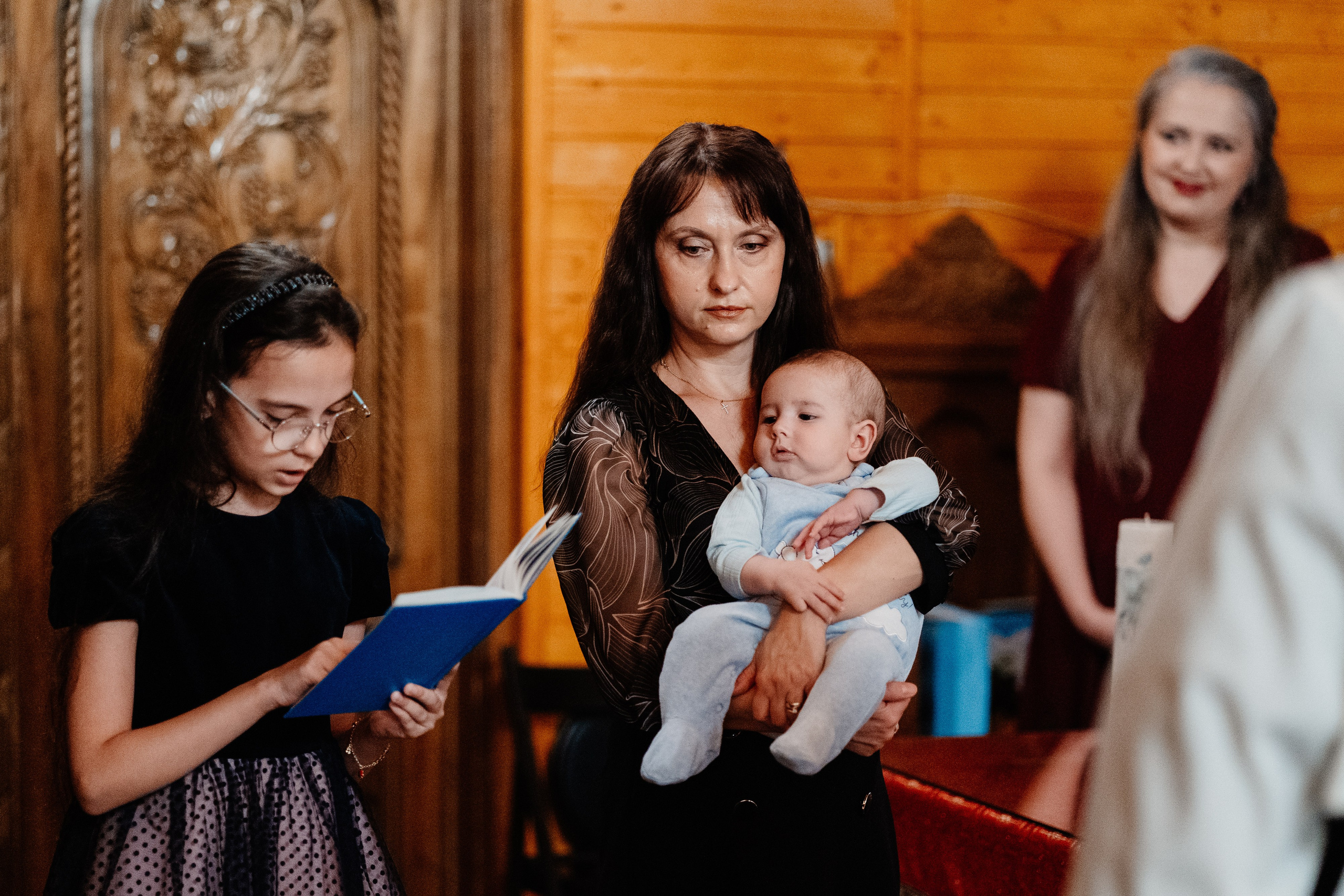 Instantaneu plin de tandrețe dintre părinți și bebeluș în ziua botezului, realizat în Bucuresti. Fotografie profesională de botez, capturând emoțiile autentice ale familiei într-un decor luminos și cald