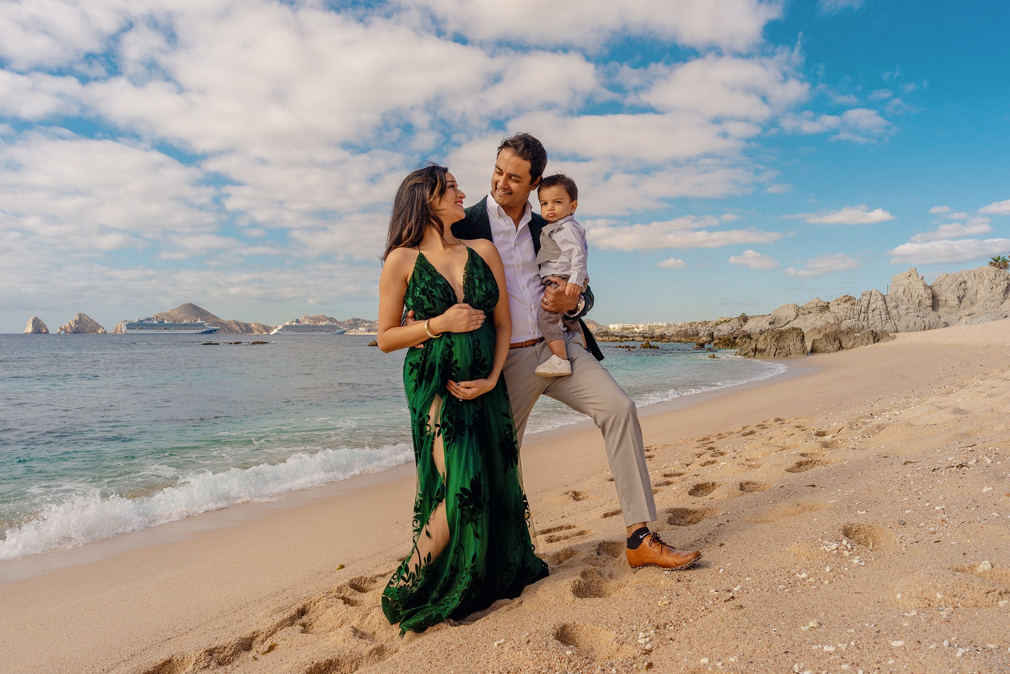 Los Cabos maternity photographer – elegant portrait of expecting mother in a dress flowing in the wind, highlighting the love, strength, and beauty of pregnancy by the sea