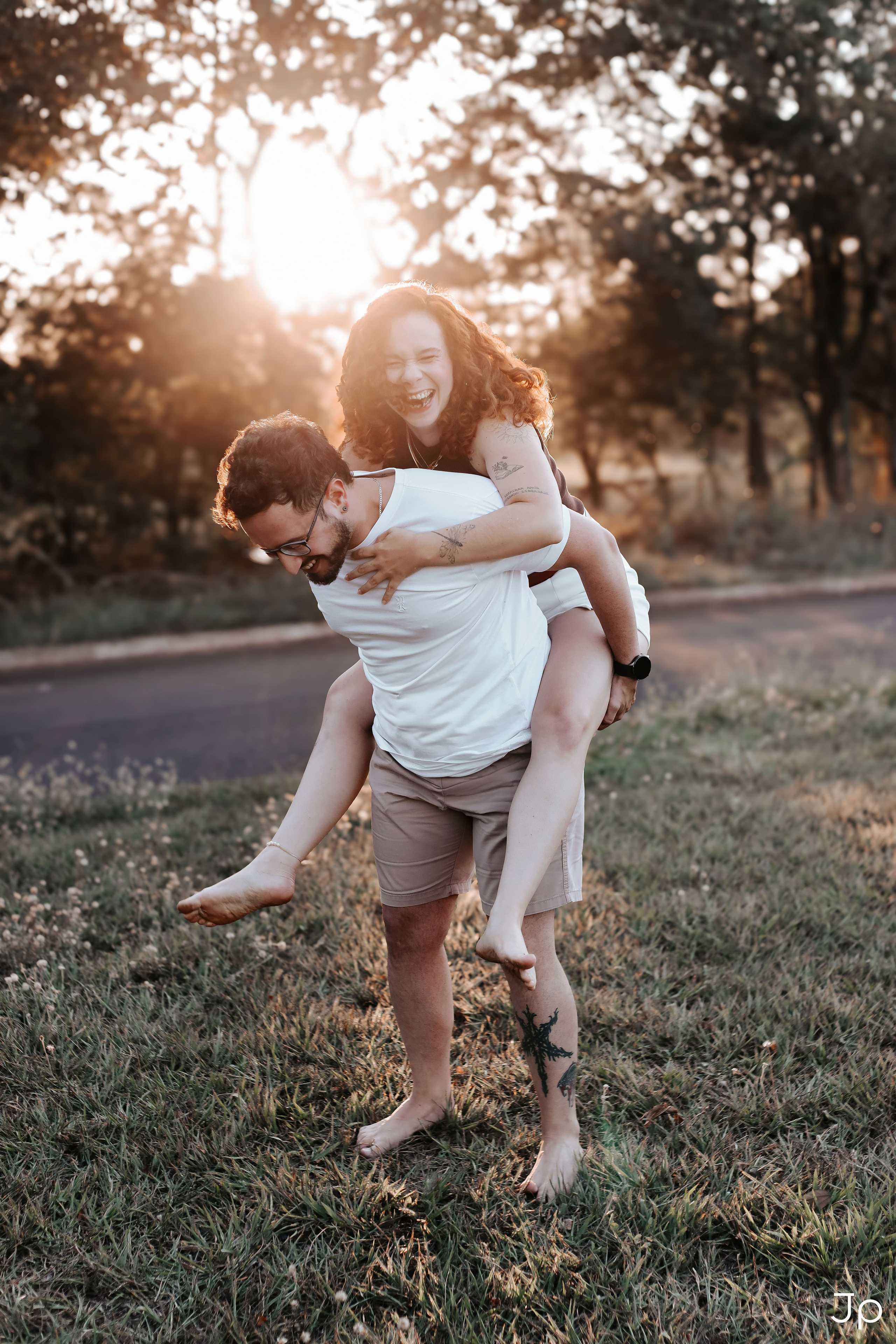 Momento divertido do casal correndo na grama em ensaio fotográfico em Bariri