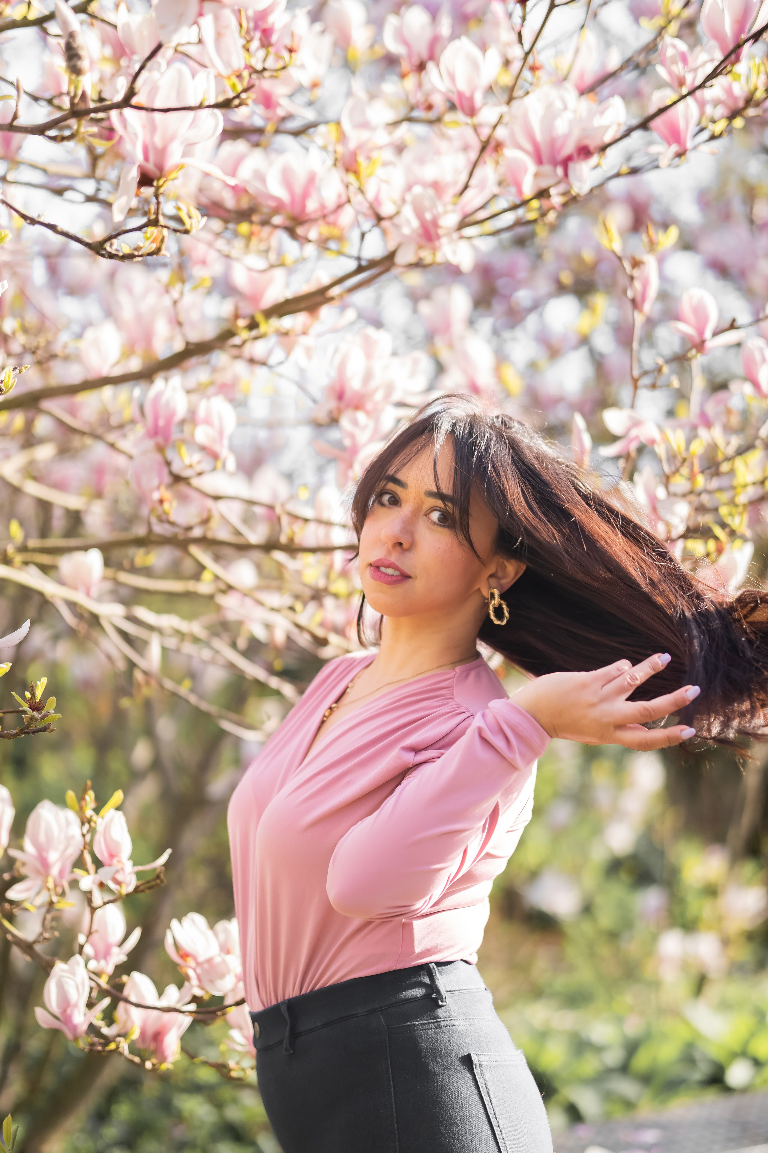 Woman standing underneath magnolia flowers