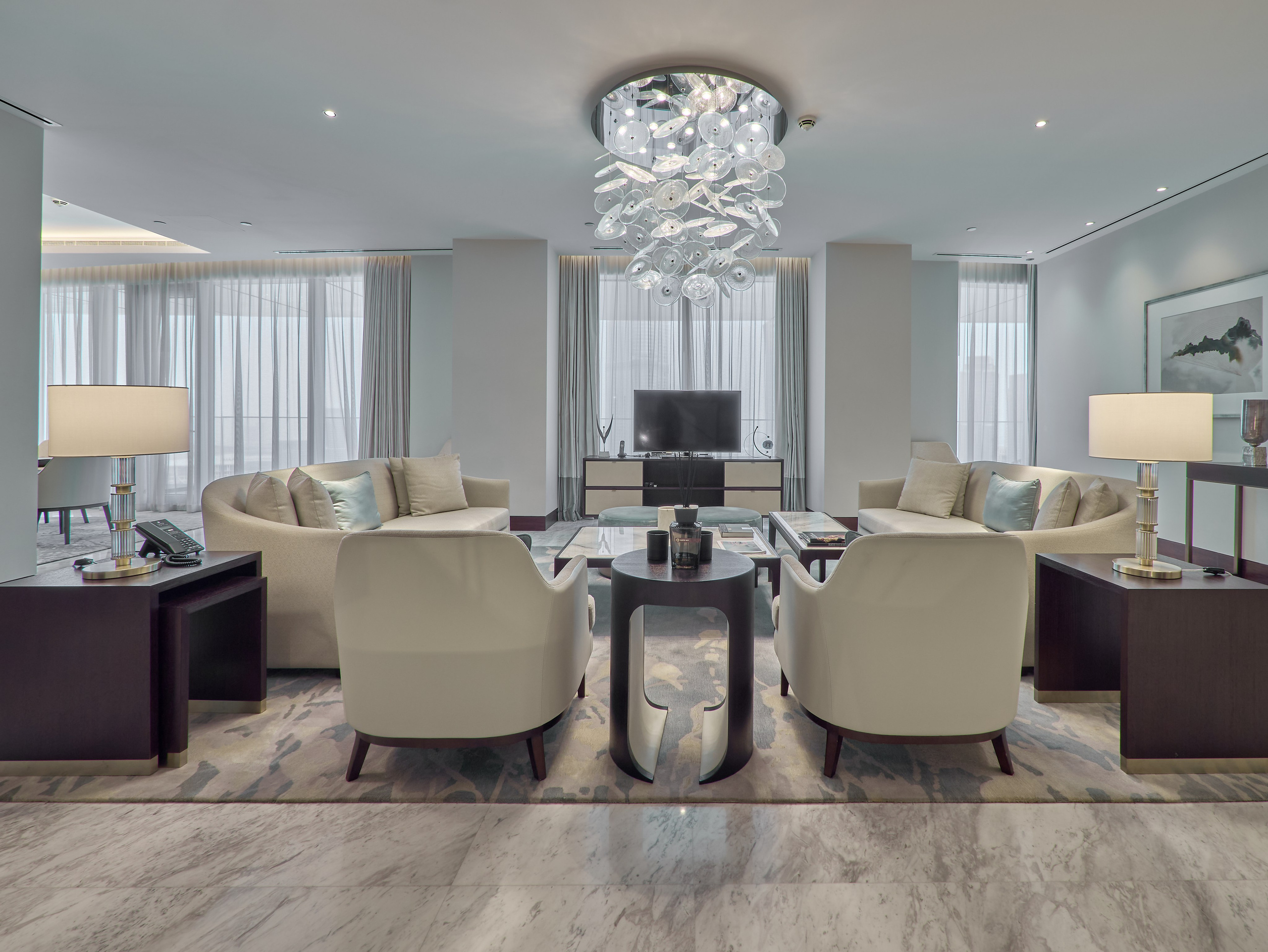 Spacious lounge with chandelier in Dubai penthouse at Address Skyview. High-end real estate photography for property listings and Airbnb.