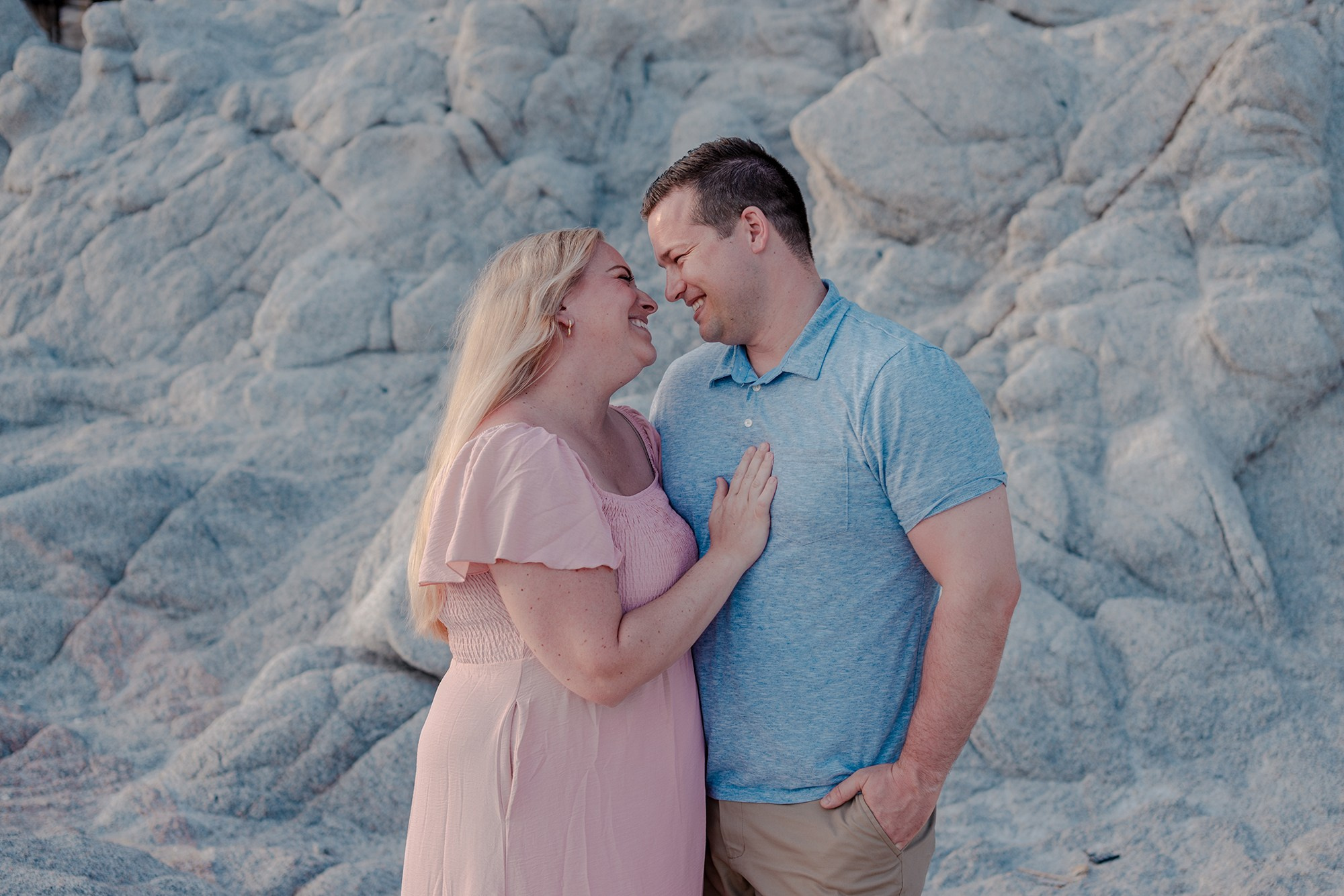 Parents with baby and grandmother posing on the beach rocks at Playa Monumentos Los Cabos Mexico