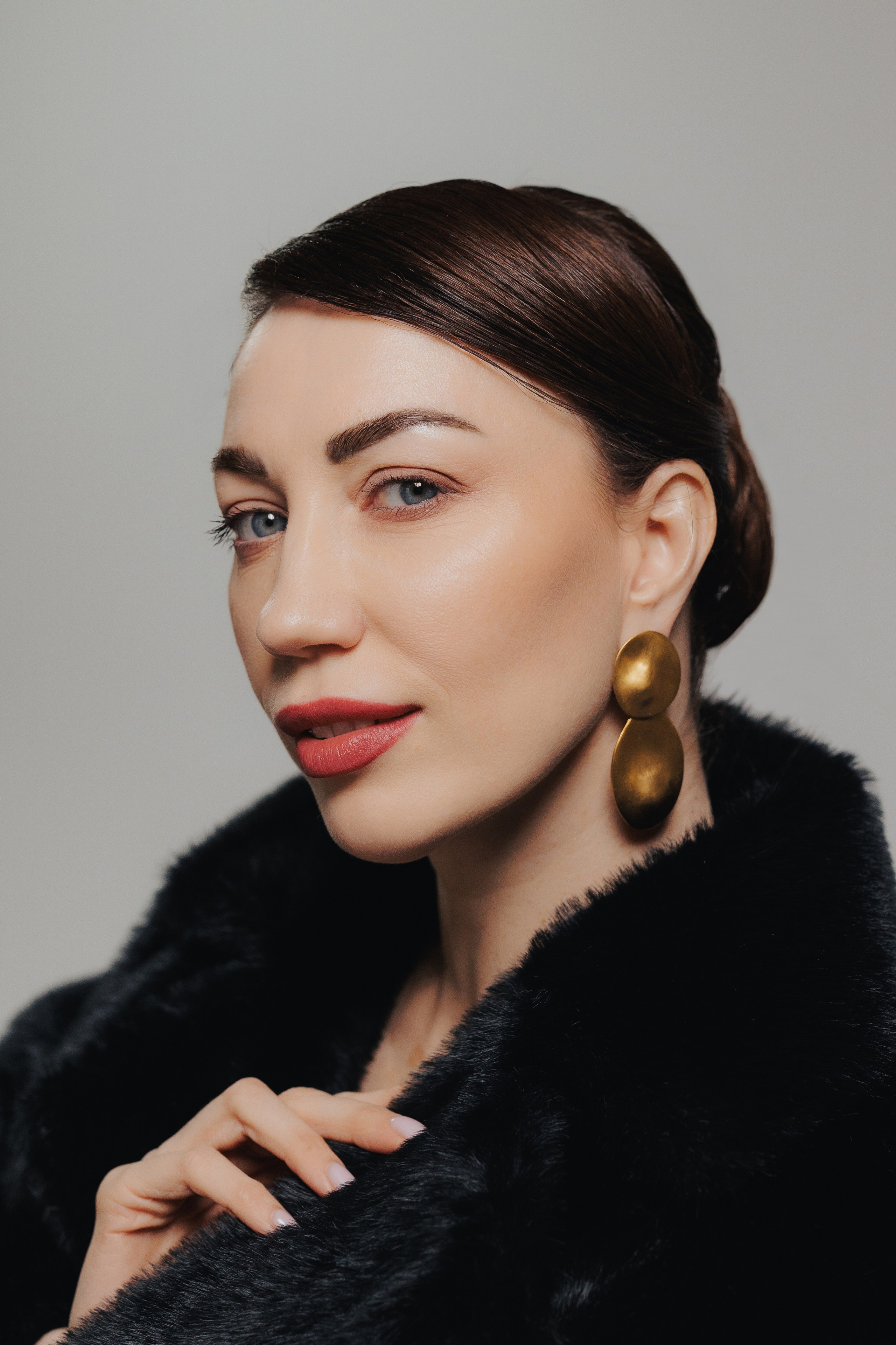 Modern editorial portrait of a woman in a black fur coat looking to the side in soft studio lighting, photographed in Leipzig, Germany. Современный редакционный портрет девушки в чёрной шубе, смотрящей в сторону, в мягком студийном освещении, снятый в Лейпциге, Германия.