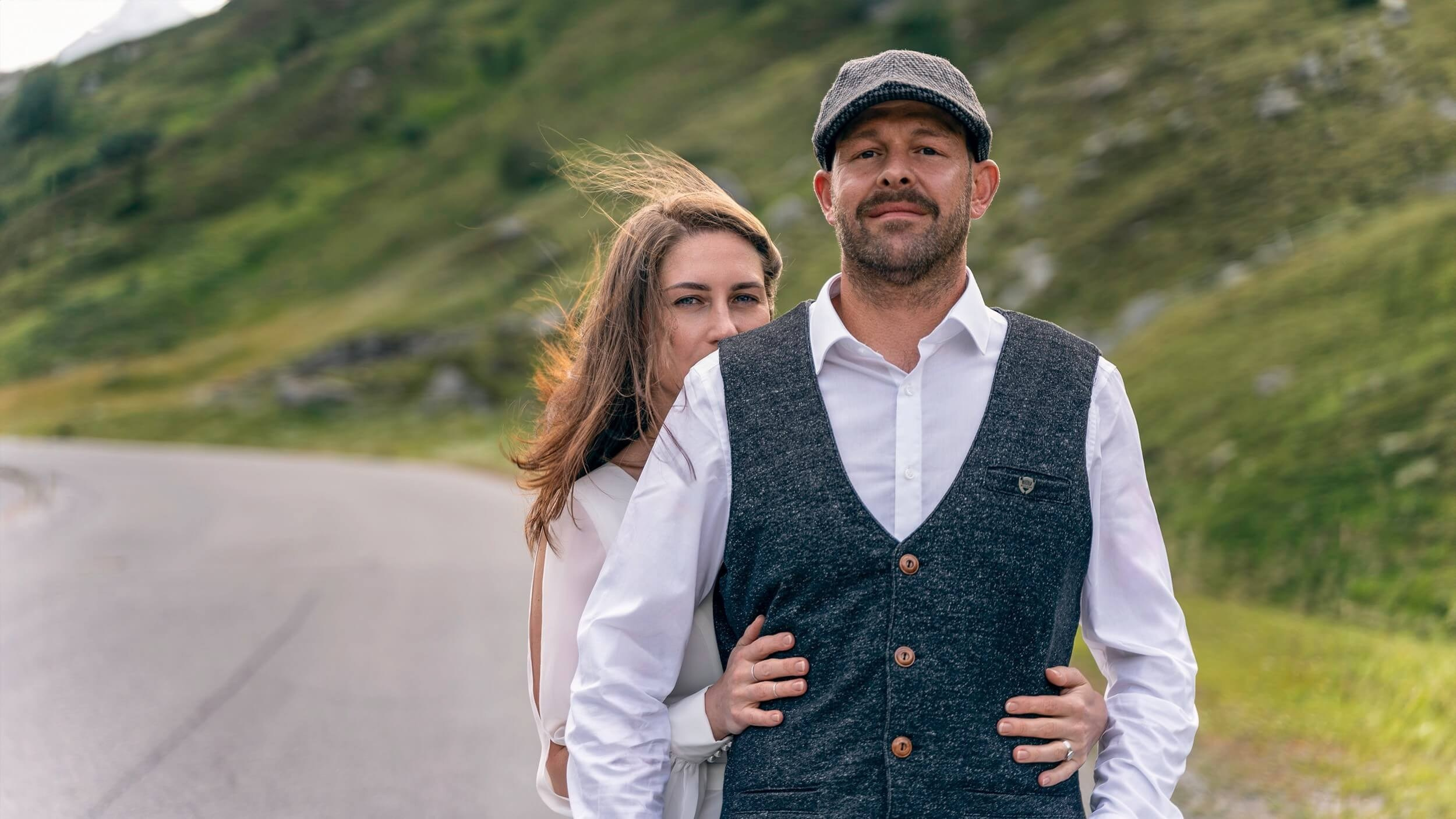 Hochzeitsfoto eines Paares auf einer Straße mit Blick auf die Berge von Sölden in den Alpen.