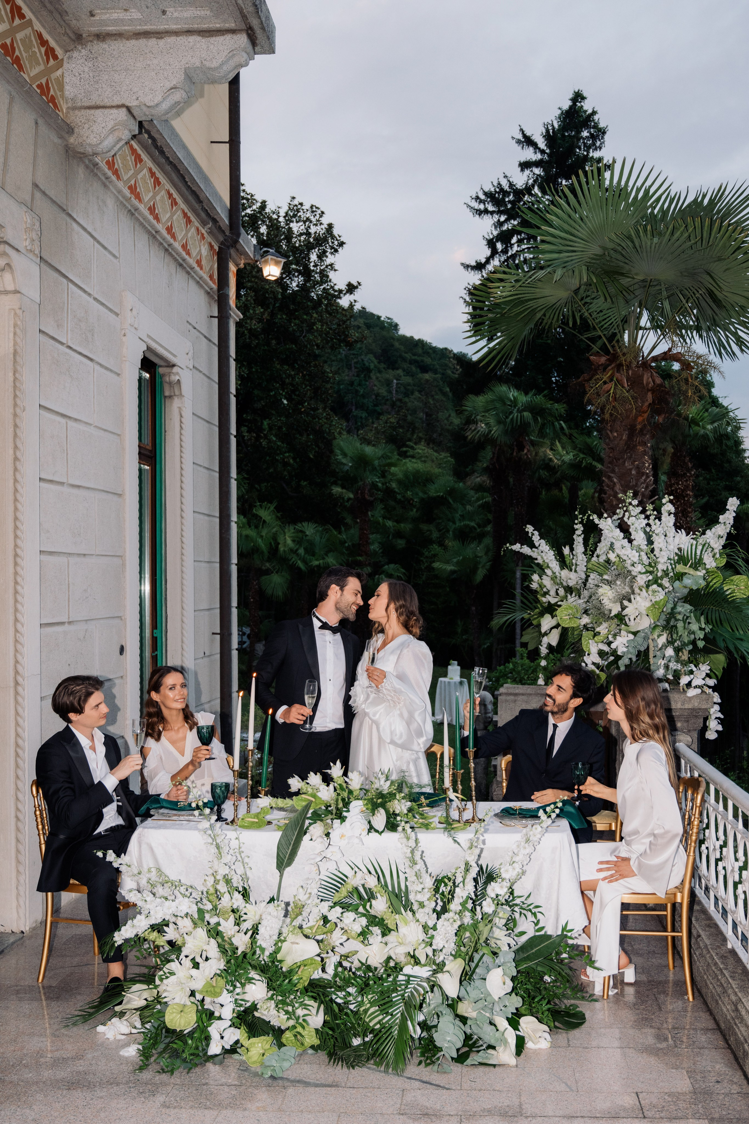 a couple kissing at a table with flowers