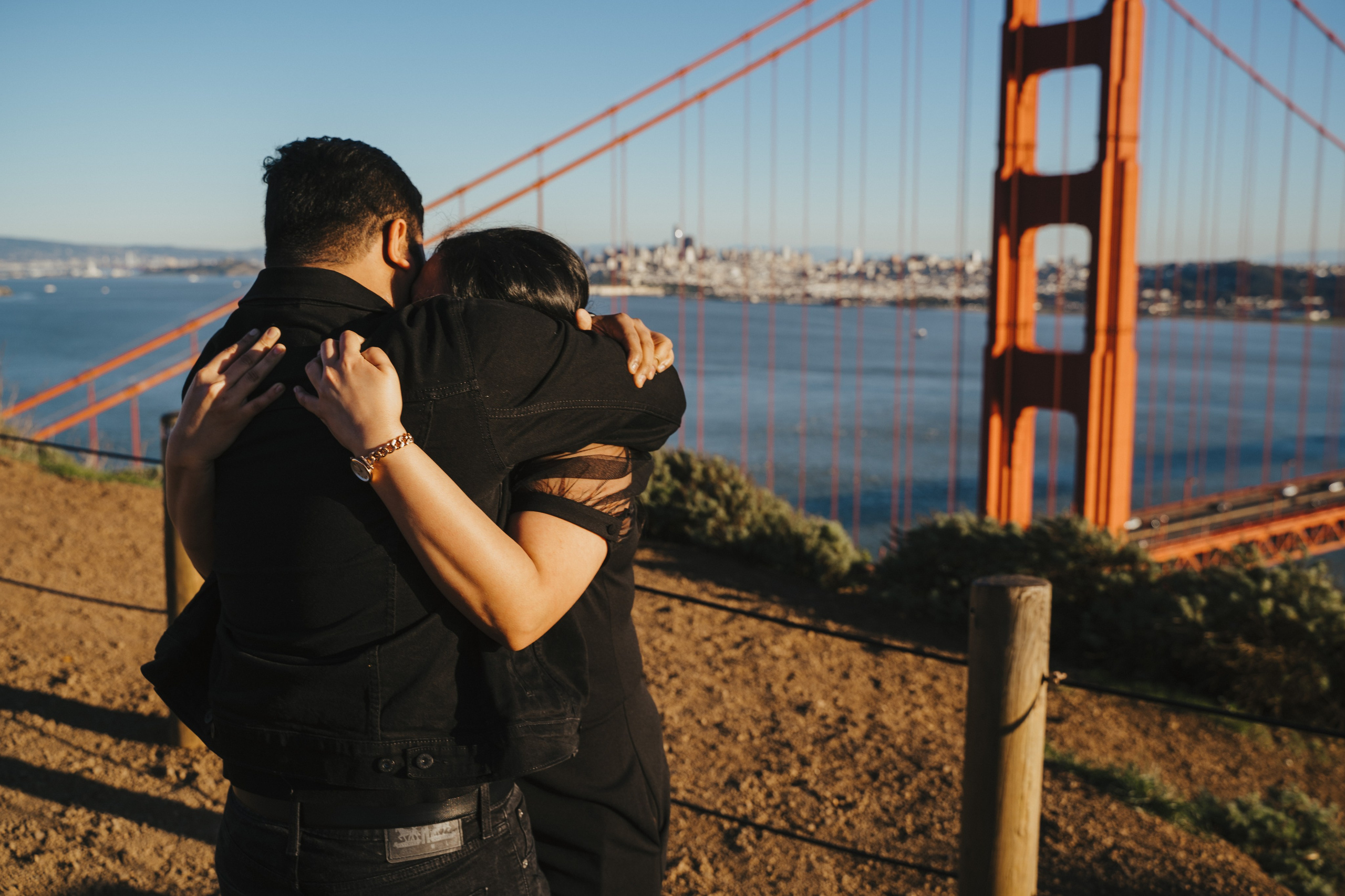 Proposal.  Overlooking the golden San Franisco Bridge sunset with a couple. Photographer Video. 