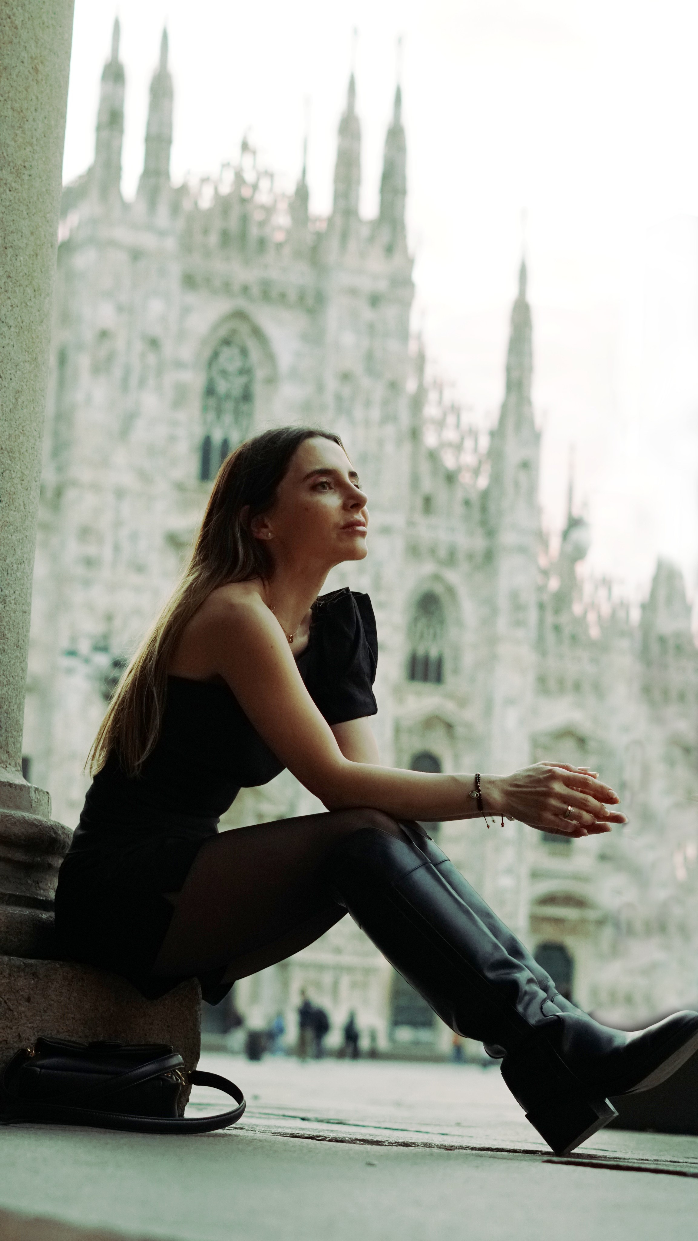 Giovane donna davanti al Duomo all’alba, mentre la città si risveglia.