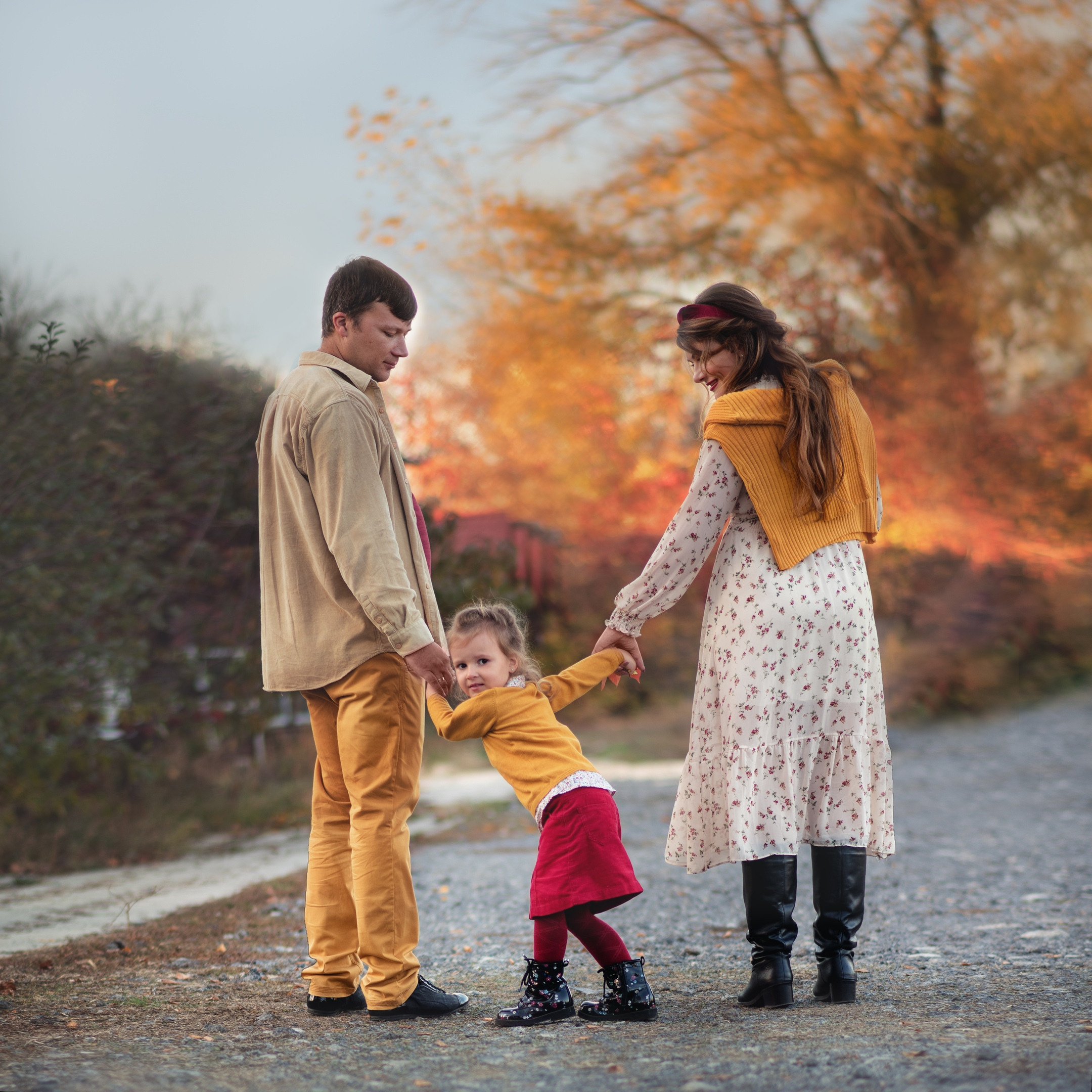 Семейная портретная фотосессия с ребёнком на природе — родители держат малыша за руки