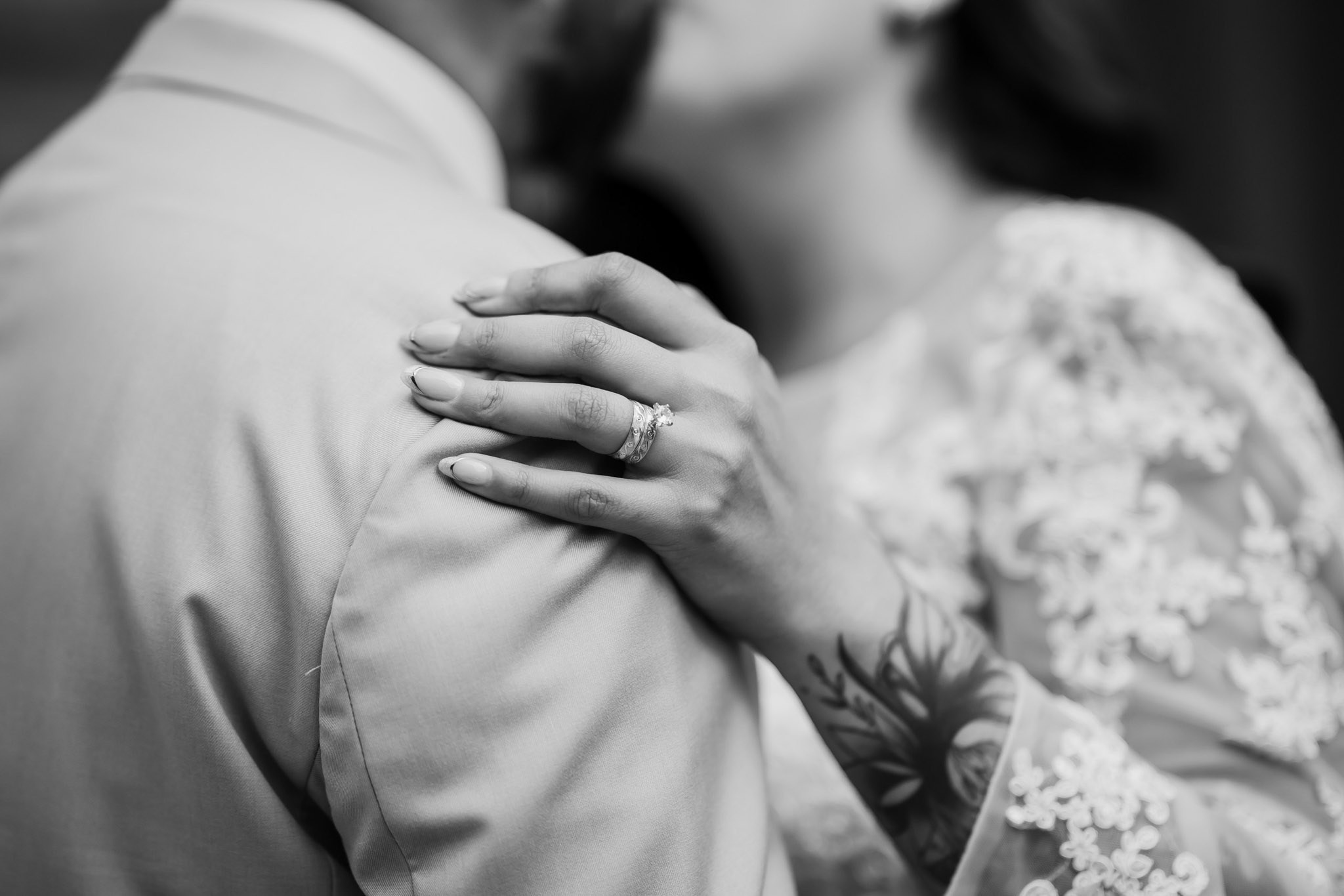 Foto artística en blanco y negro de novia abrazando al novio durante boda en Tijuana, fotografía documental de bodas en Baja California, fotógrafo profesional estilo editorial y romántico