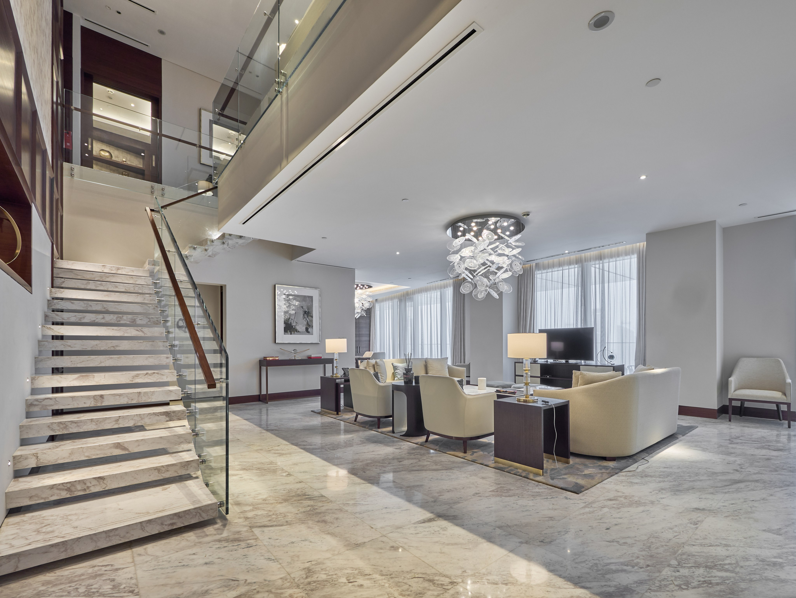 Marble staircase with glass balustrade in Address Skyview penthouse, Dubai. Real estate photo highlighting upscale interior details.