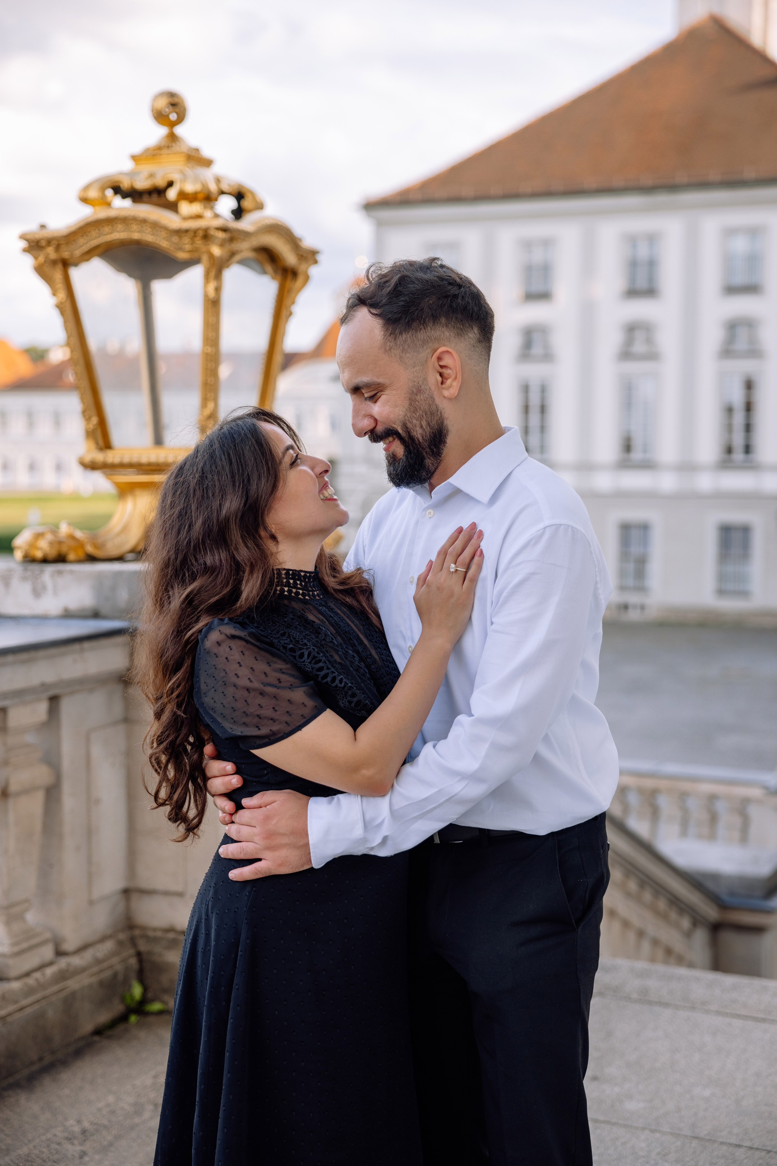 Braut schaut den Bräutigam verliebt an vor dem Schloss Nymphenburg
