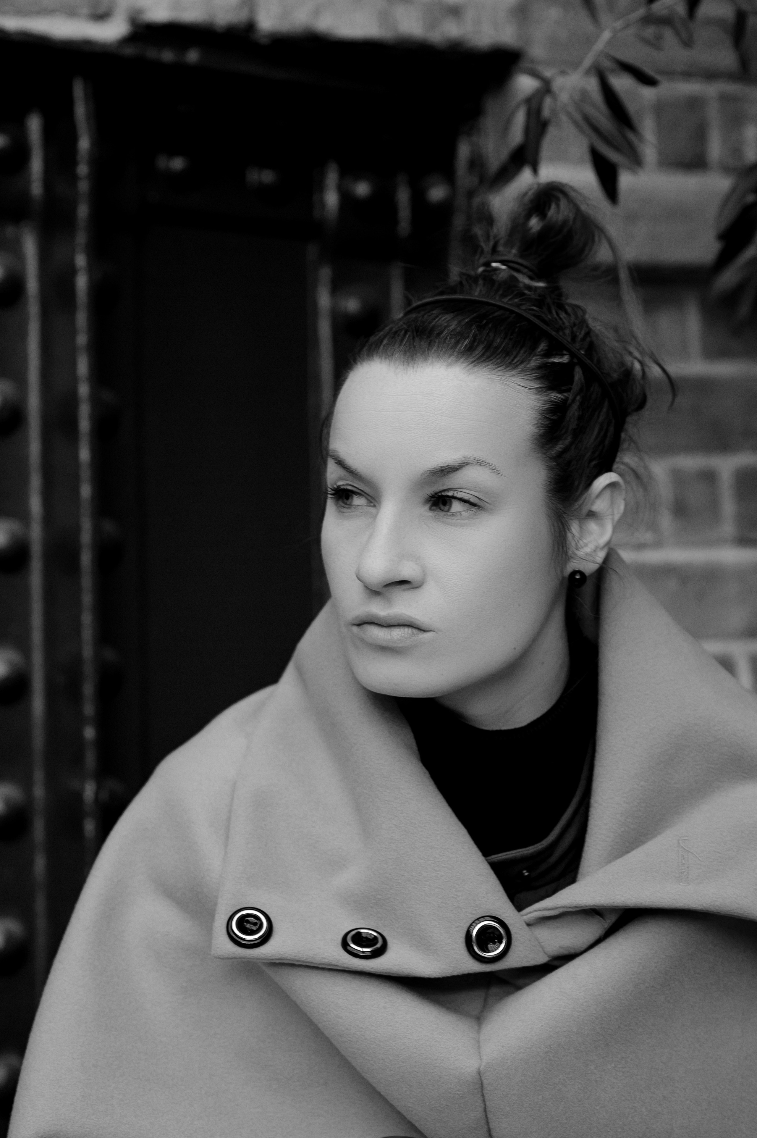Classic female portrait against a brick wall background.
