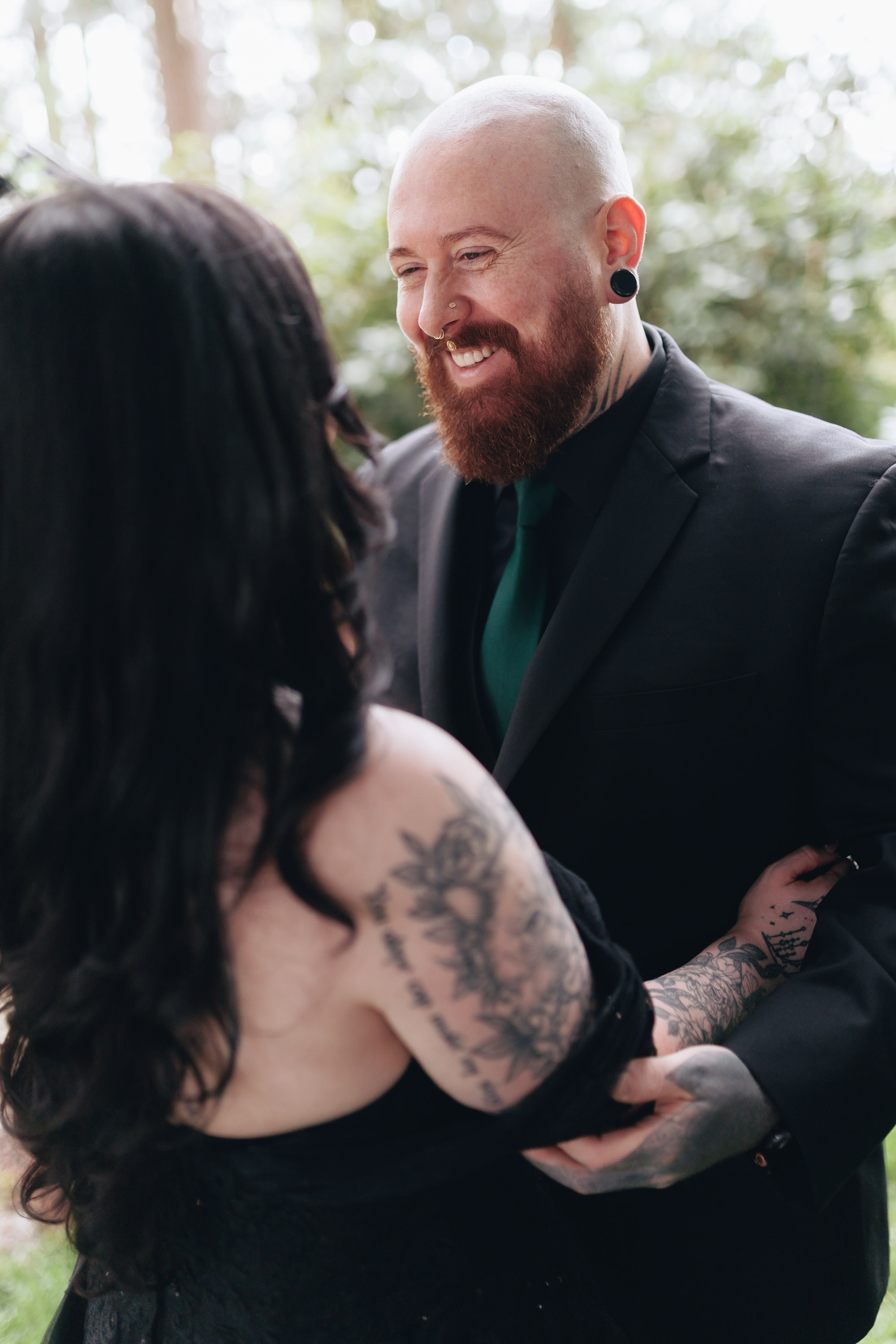 Tattooed couple smiling and hugging, alternative wedding style