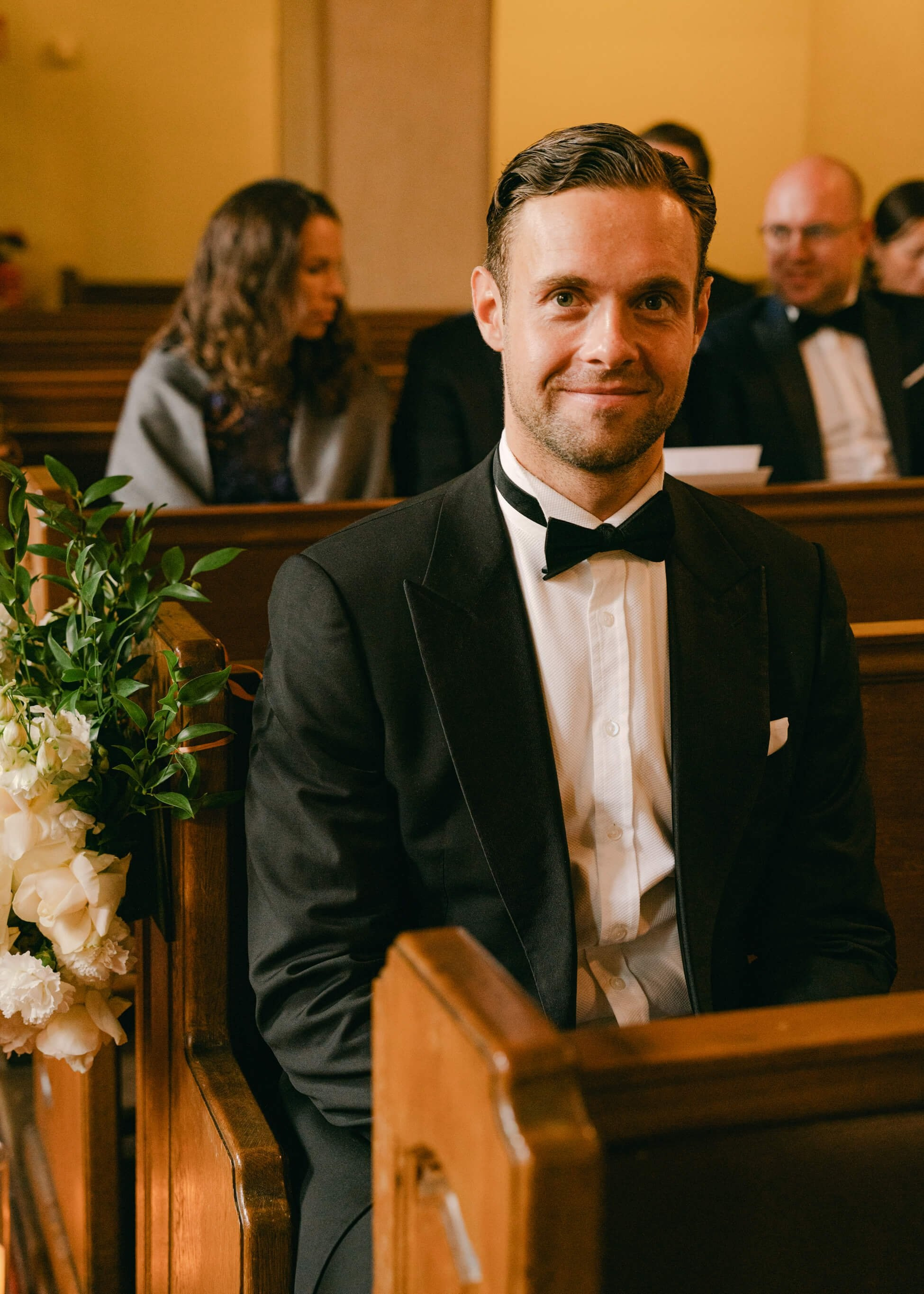 Groom at church during ceremony, black bow tie with boutonnière, luxury black tie wedding Frankfurt