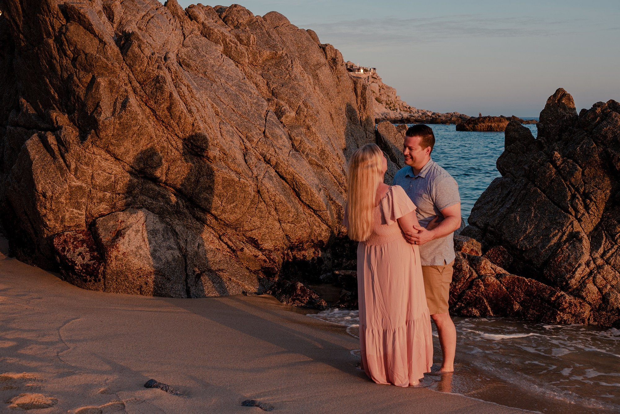 Family with baby photographed against dramatic sunset sky at Playa Monumentos Cabo San Lucas Mexico