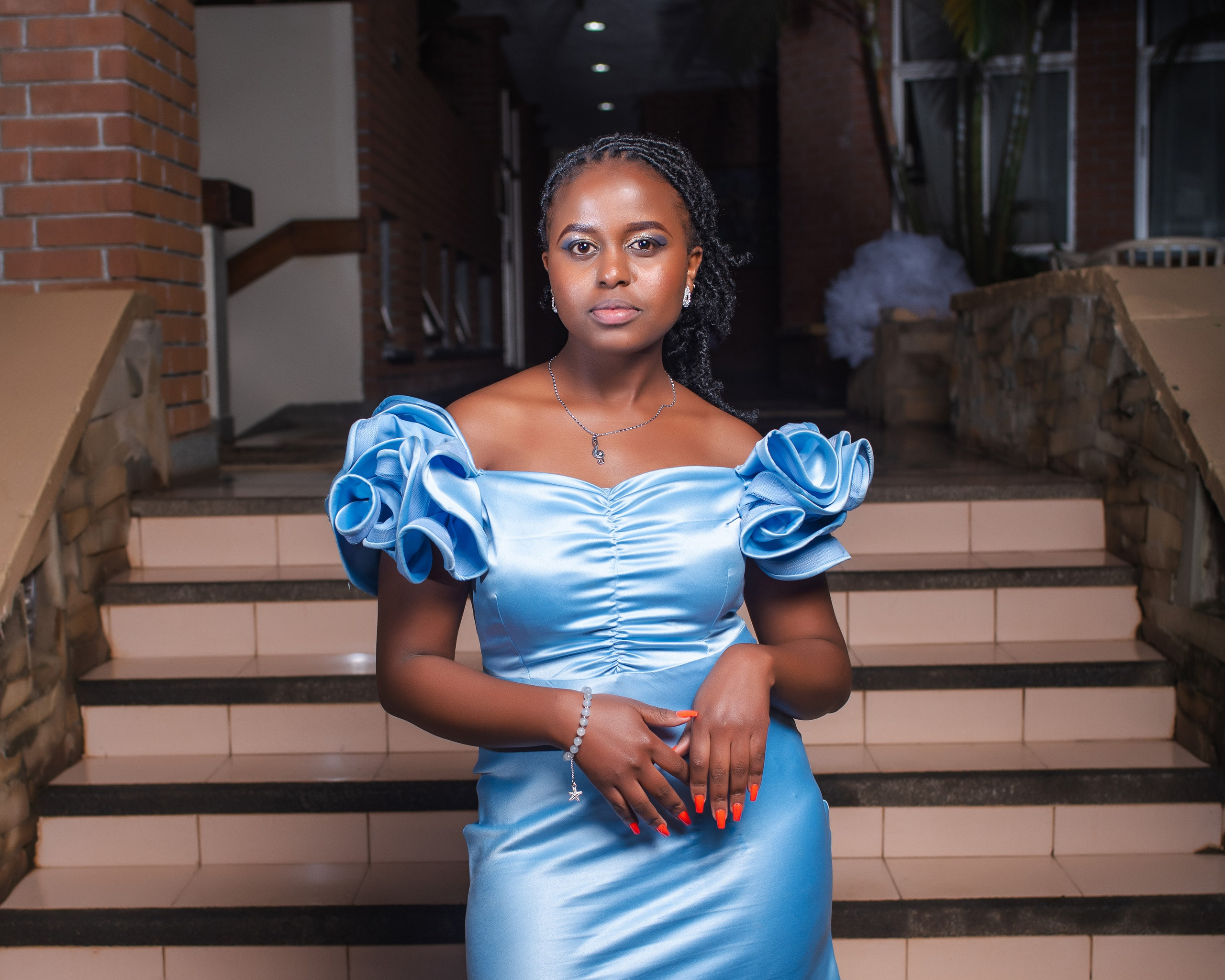 Confident young woman in blue off-shoulder dress — elegant portrait by Nick Ouma Photography, Nairobi