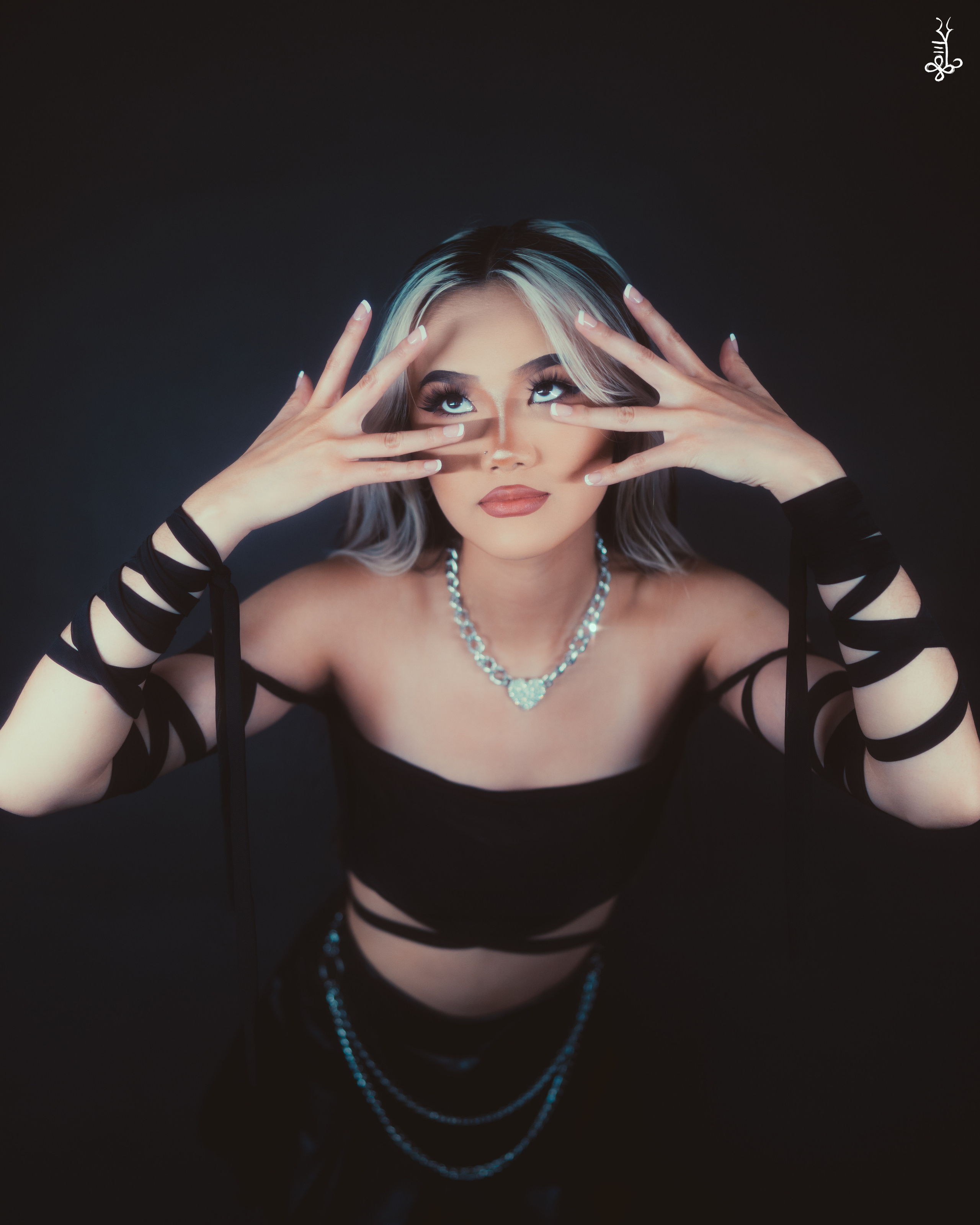 Model with arms extended and sharp gaze, dressed in edgy black mesh fashion