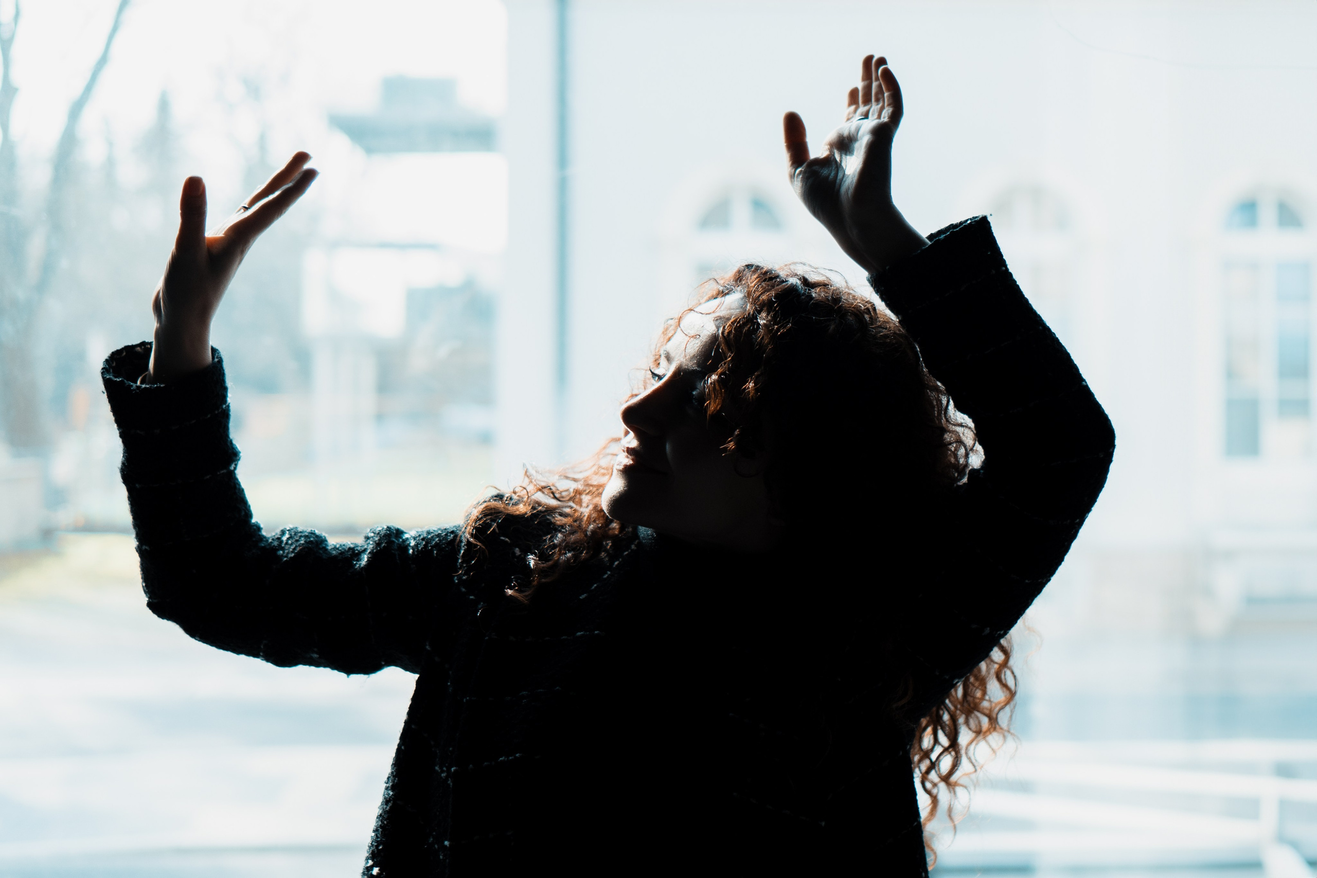 Schatten und Silhouette, Frau hebt Arme im Licht – kreative Portraitfotografie Dresden
