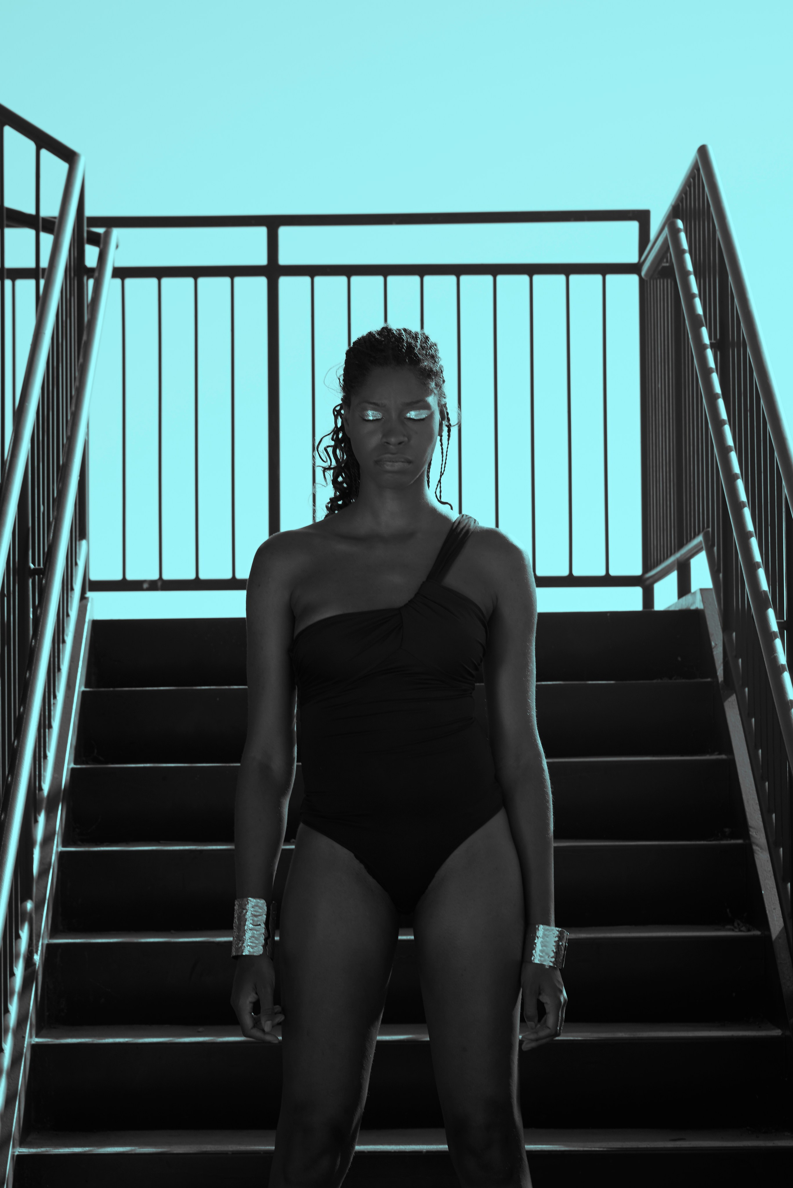 Model standing on an outdoor staircase in a modern urban setting