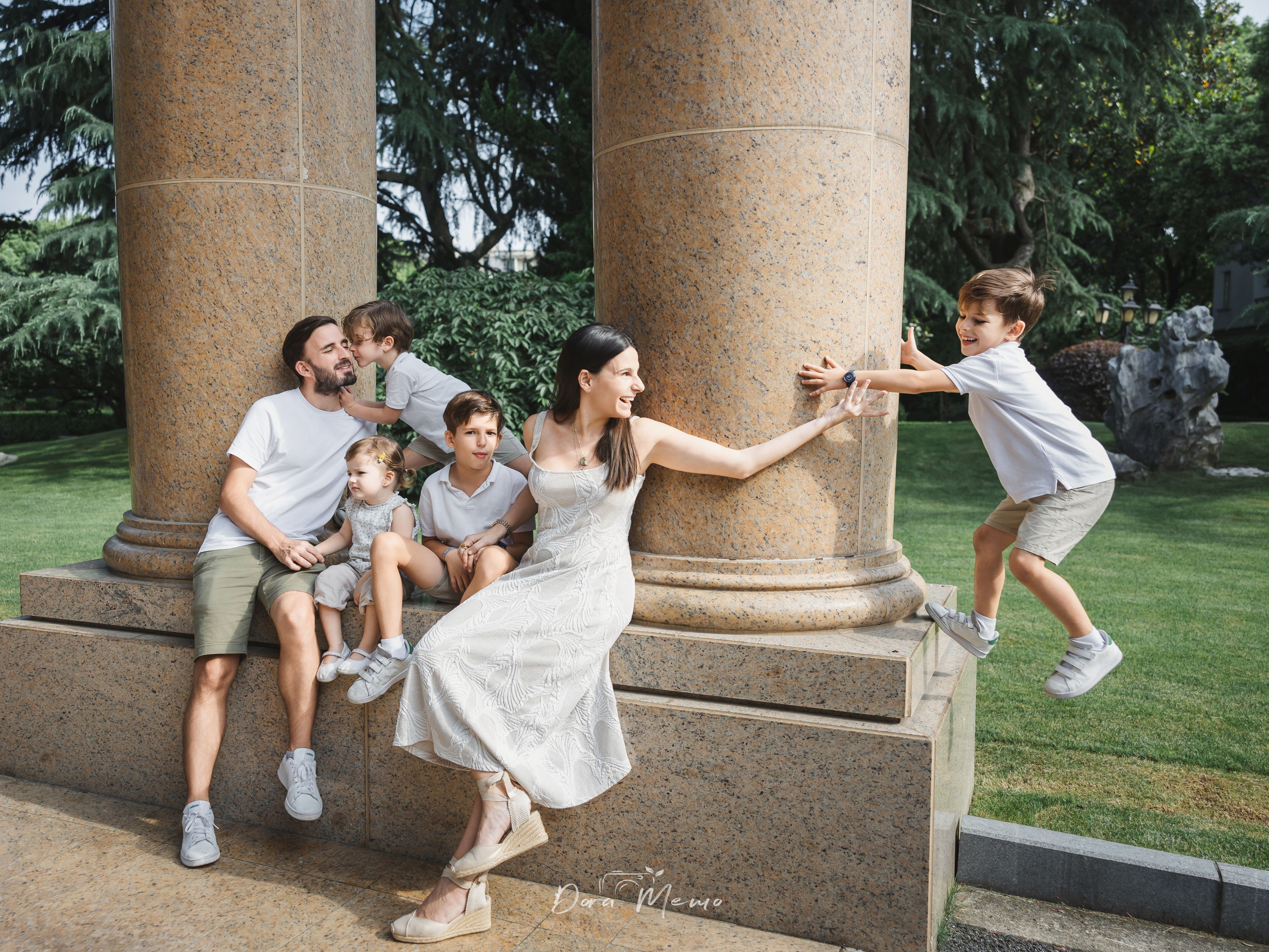  Whole family gathered on stone steps | A family of six sitting together on stone steps, warm and connected