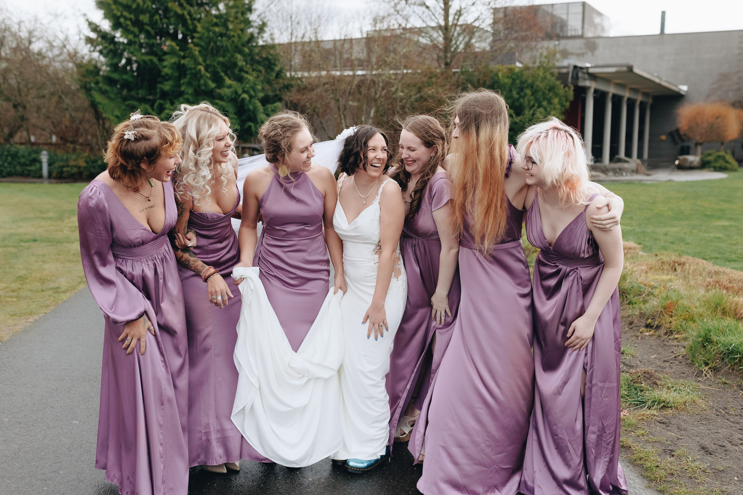Bride and bridesmaids laughing outdoors, joyful wedding moment