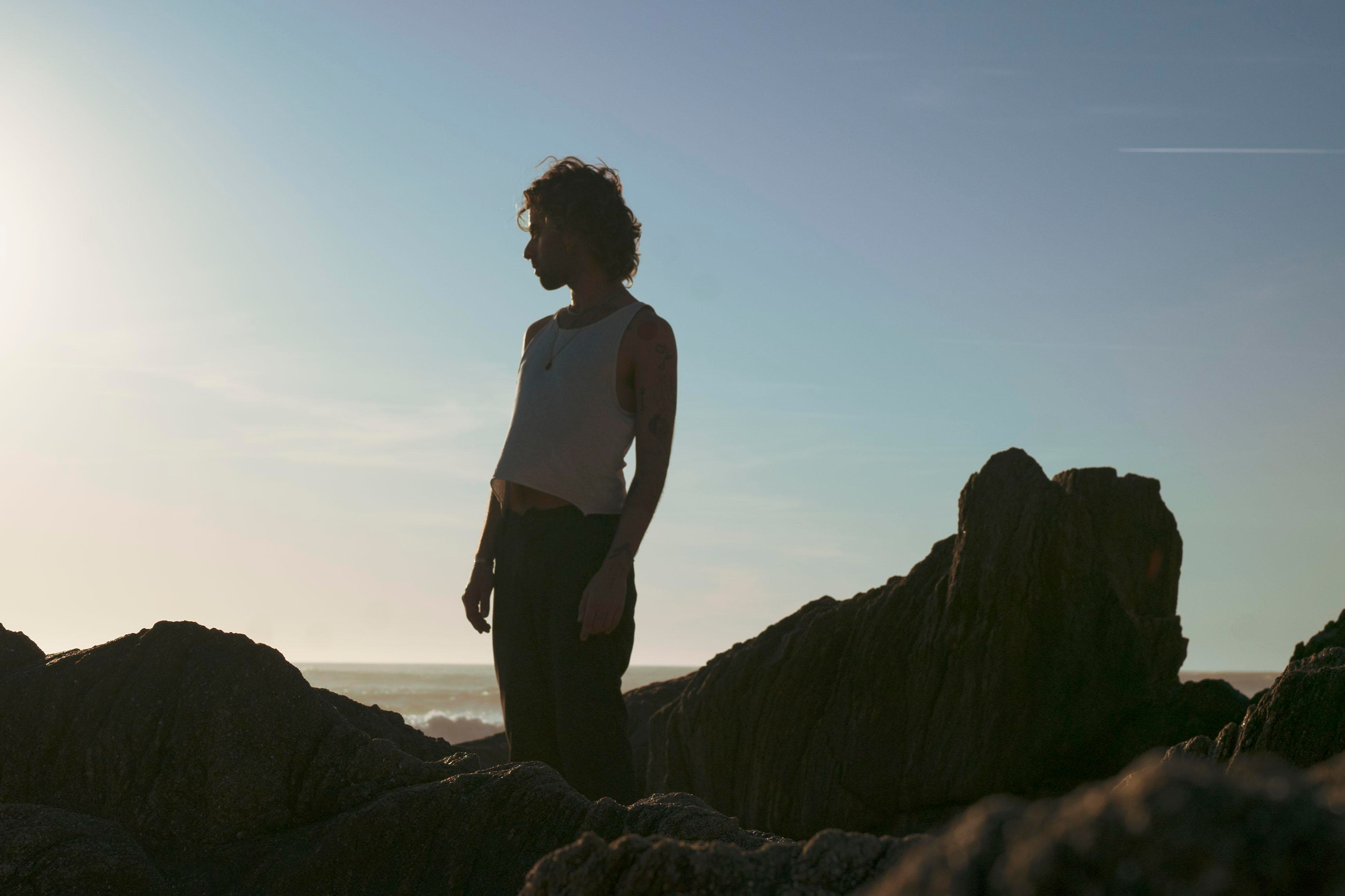 Silhouette of a person with a sunset sky in the background.