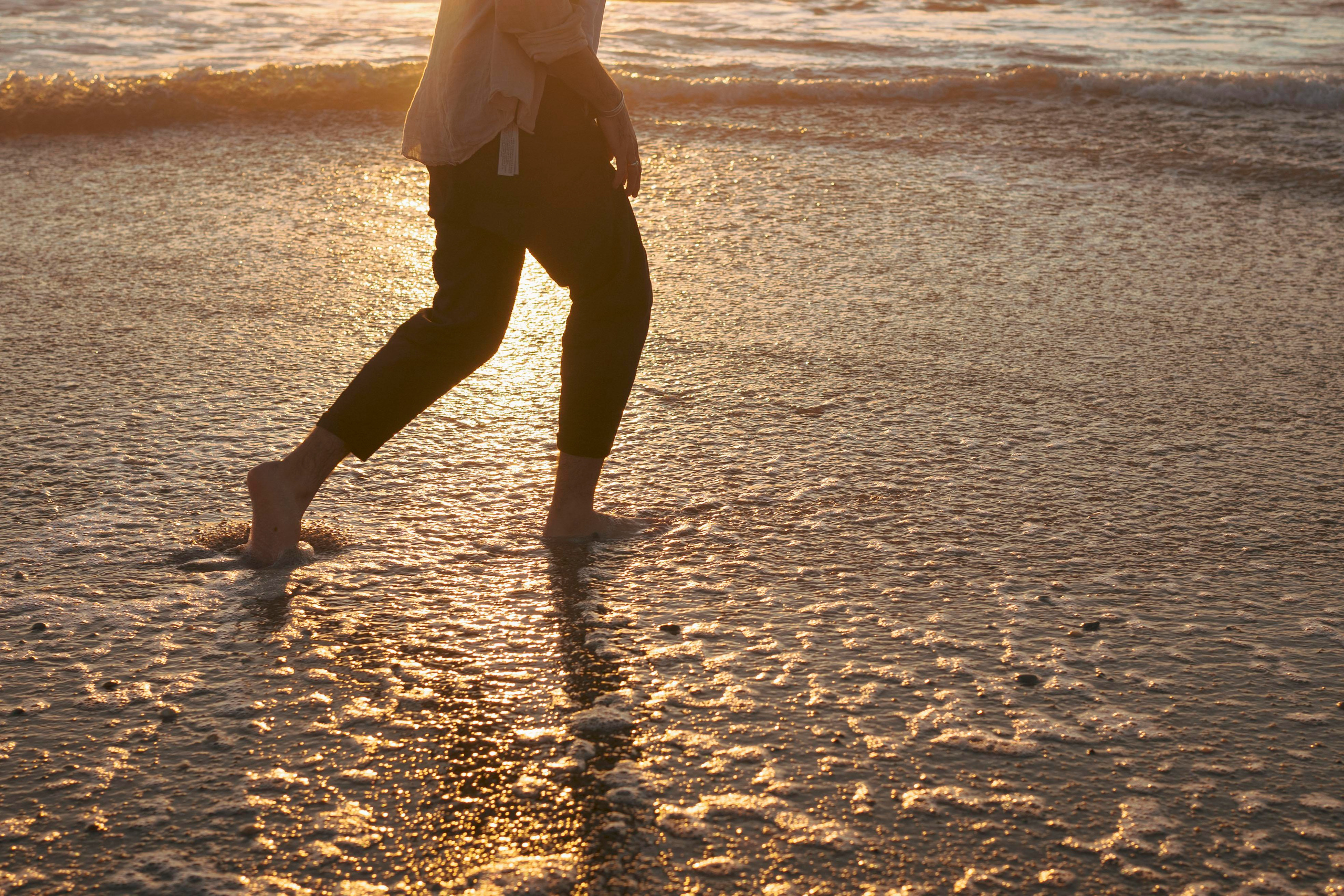 A person running into the sunset on an ocean beach. Sunset on the ocean.